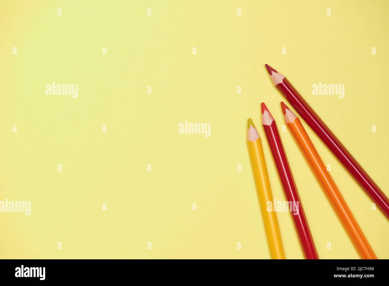 Gelber Hintergrund mit Farbstiften in warmer Farbe Stockfoto