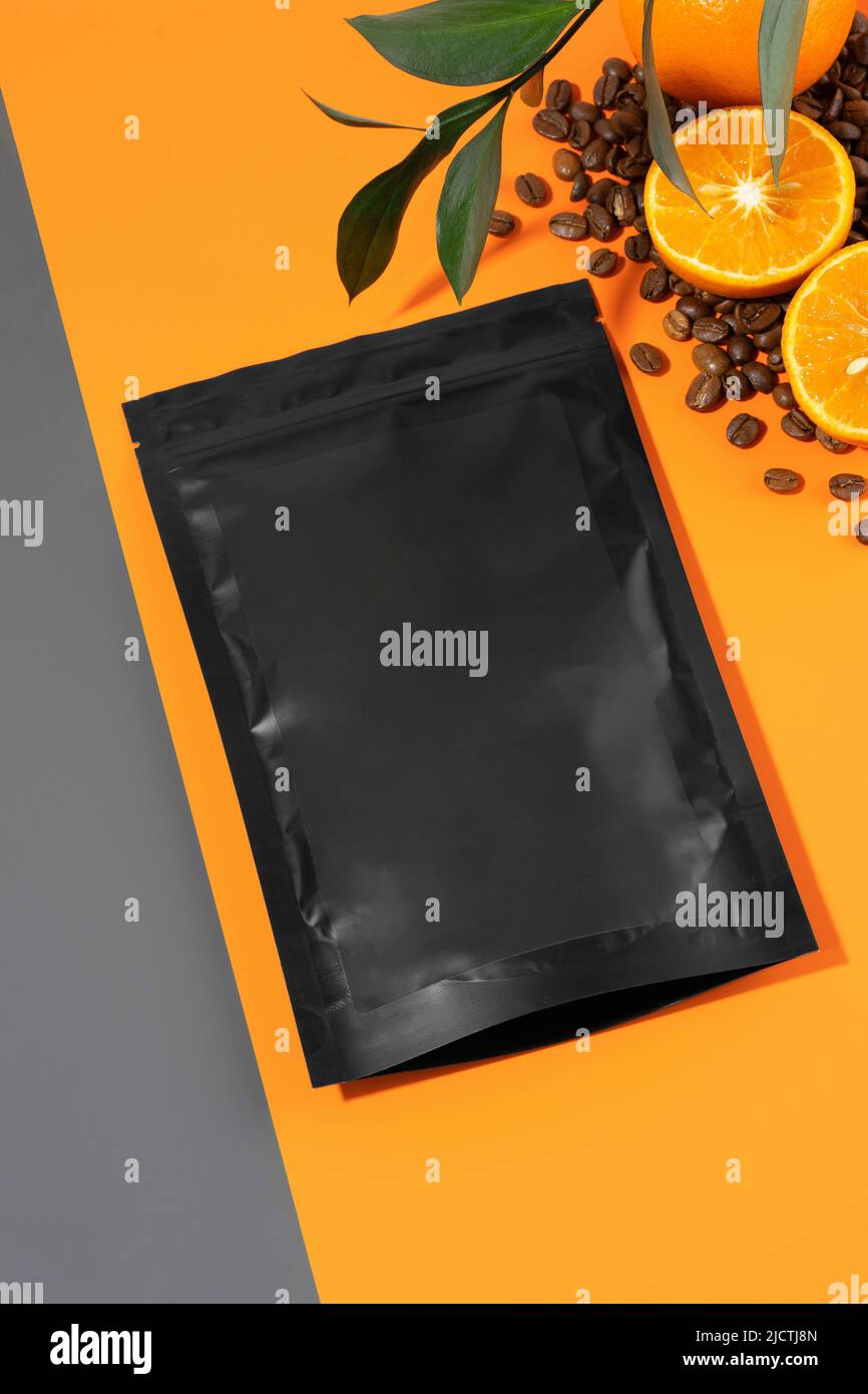 Eine Packung Anti-Cellulite-Peeling auf einem orangen Hintergrund. Körperpeeling mit ätherischen Ölen aus Kalk, Kaffee und Mandarine. Kosmetisches Produkt Stockfoto