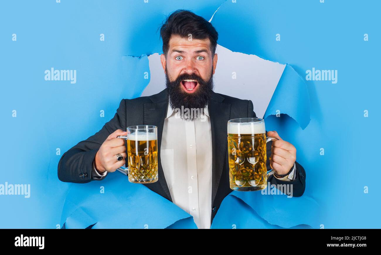 Bärtiger Mann mit einem Becher Bier schaute durch das Papierloch. Lager und dunkles Ale. Getränke, Alkohol, Bar. Stockfoto