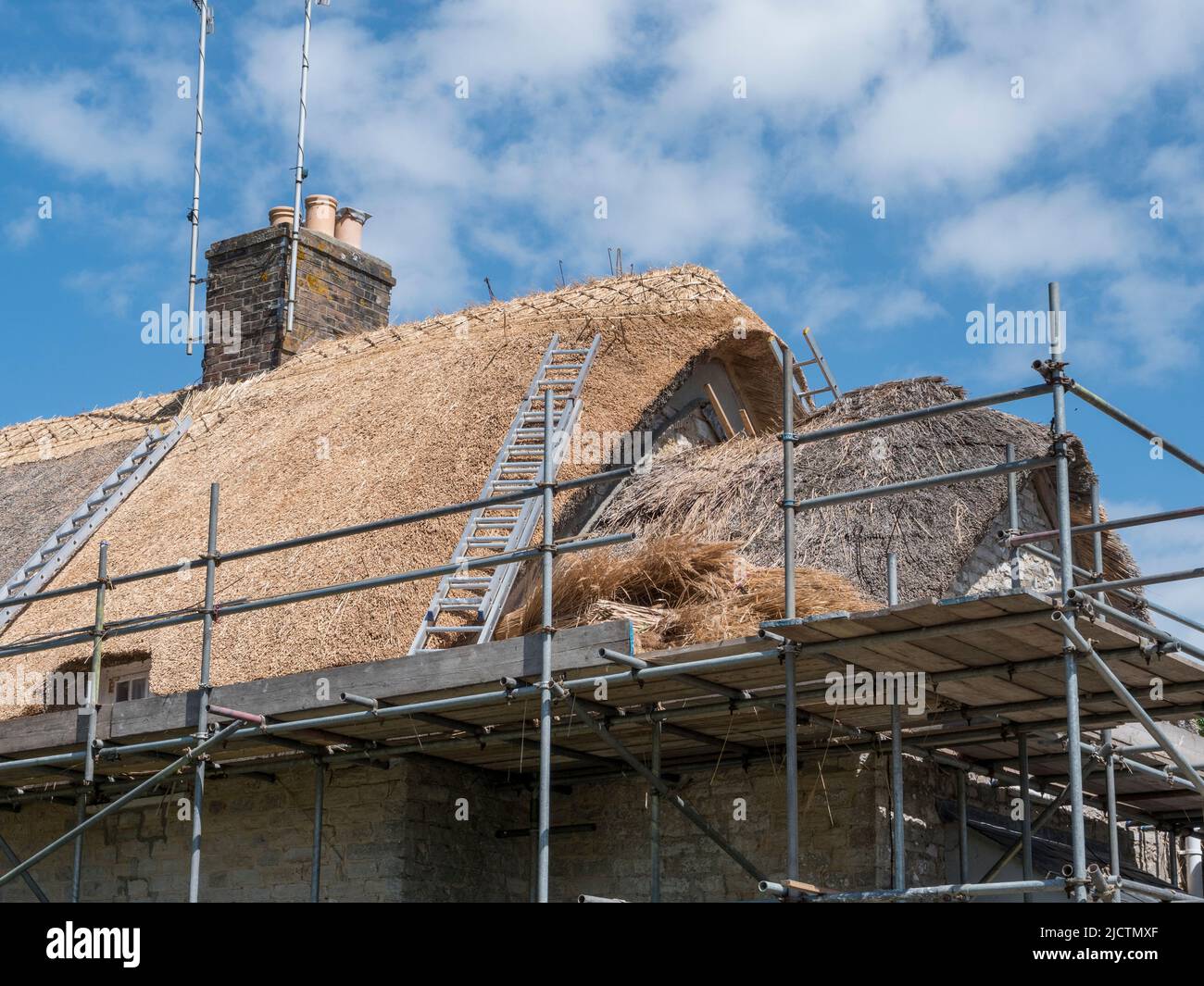 Detail zeigt ein Reetdach, das auf einem Steinhäuschen in Kimmeridge, Wareham, Dorset, Großbritannien, repariert wird. Stockfoto