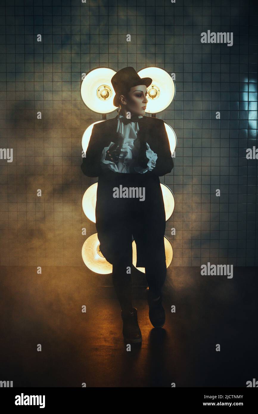 Schwanger Mädchen auf dem Bild eines dicken Mannes vor dem Hintergrund von Lampen in der Dunkelheit Stockfoto