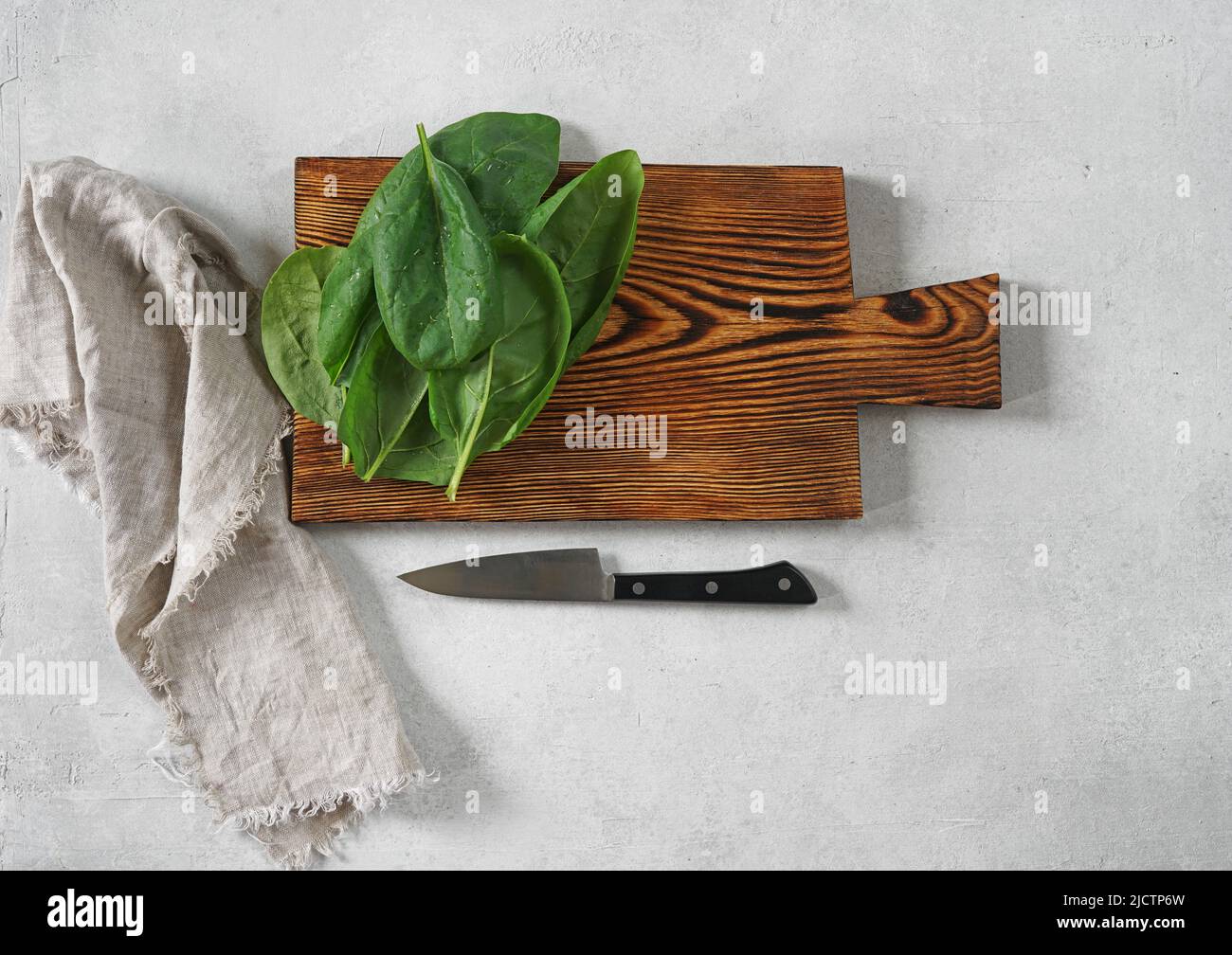 Große saftige Spinatblätter auf einem Schneidebrett, Nahaufnahme Stockfoto