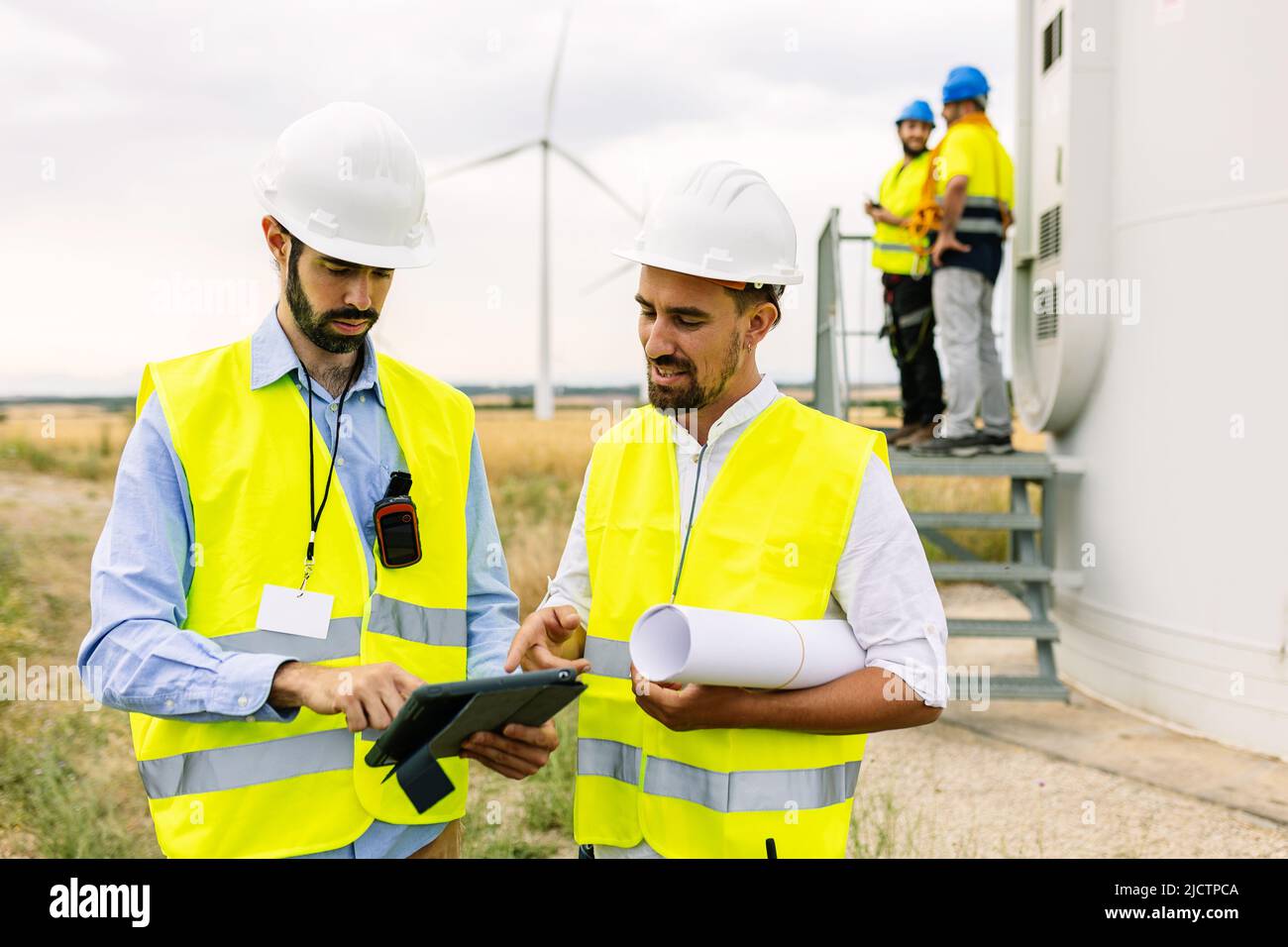 Zwei junge Wartungstechniker arbeiten im Windturbinenpark Stockfoto