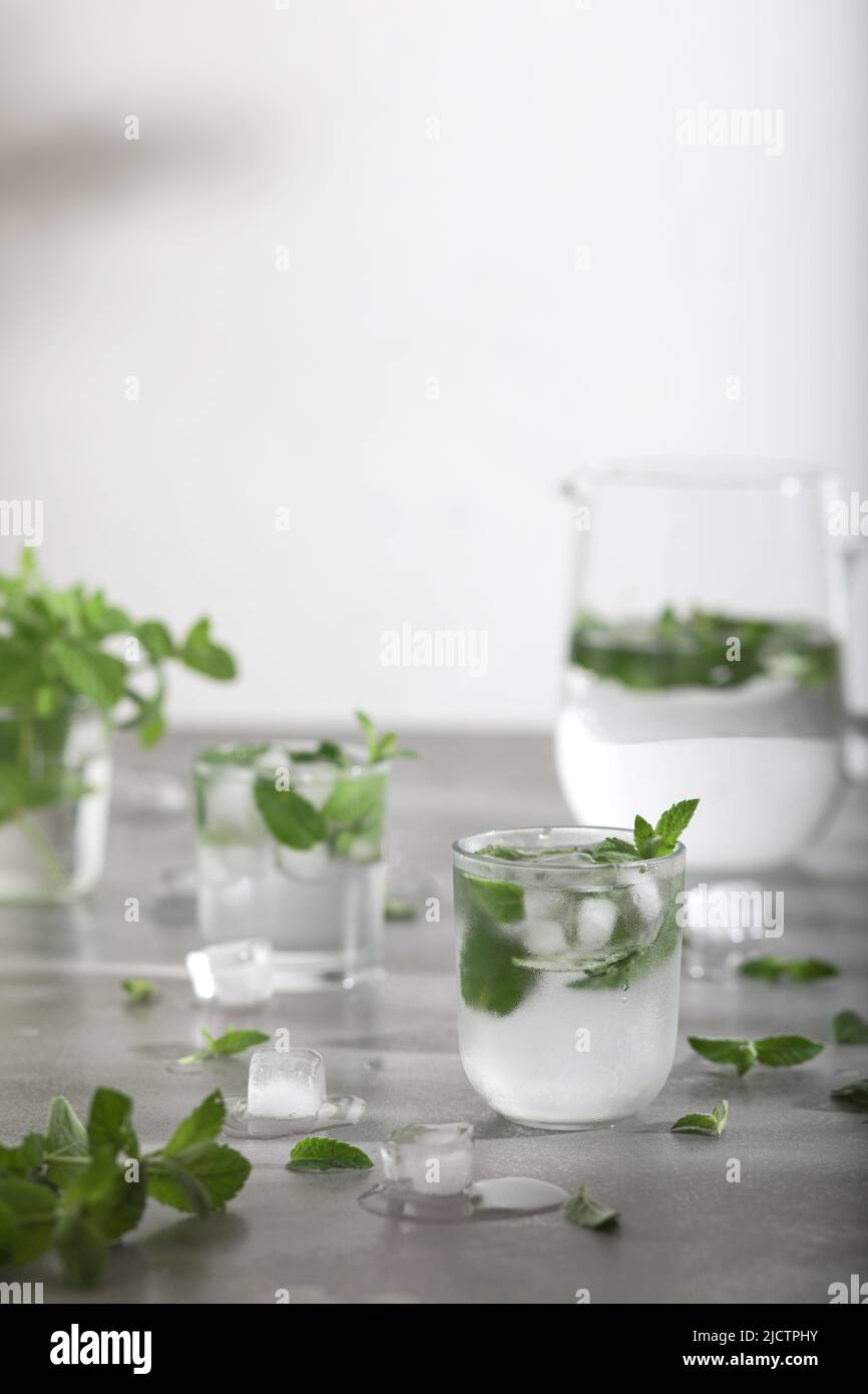 Glas kaltes Wasser mit frischen Minzblättern und Eiswürfeln Stockfoto