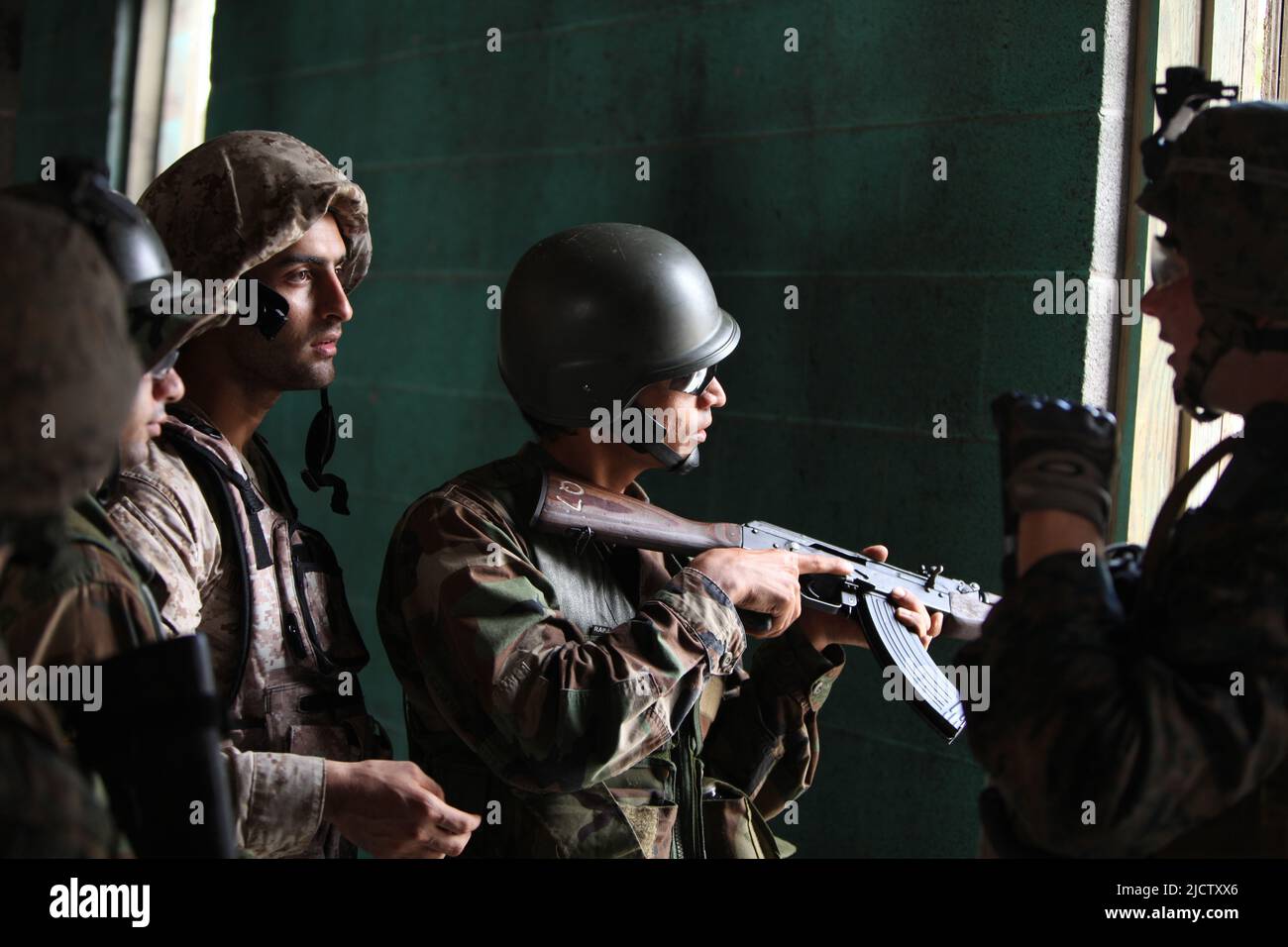 Ein US-Marine mit Charlie Company, 1. Bataillon, 8. Marine Regiment (1/8), 2D Marine Division, leitet einen Soldaten der Nationalen Armee Afghanistans Stockfoto