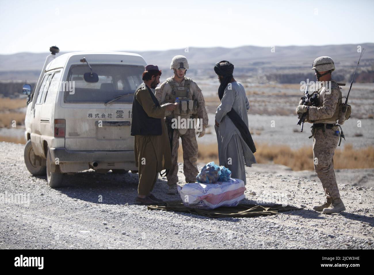 U.S. Marine Corps Sgt. Hiram V. Ruiz (rechts) mit Weapons Company, 1. Bataillon, 8. Marine Regiment (1/8), Regimental Combat Team 6, stoppt einen Afghanen Stockfoto