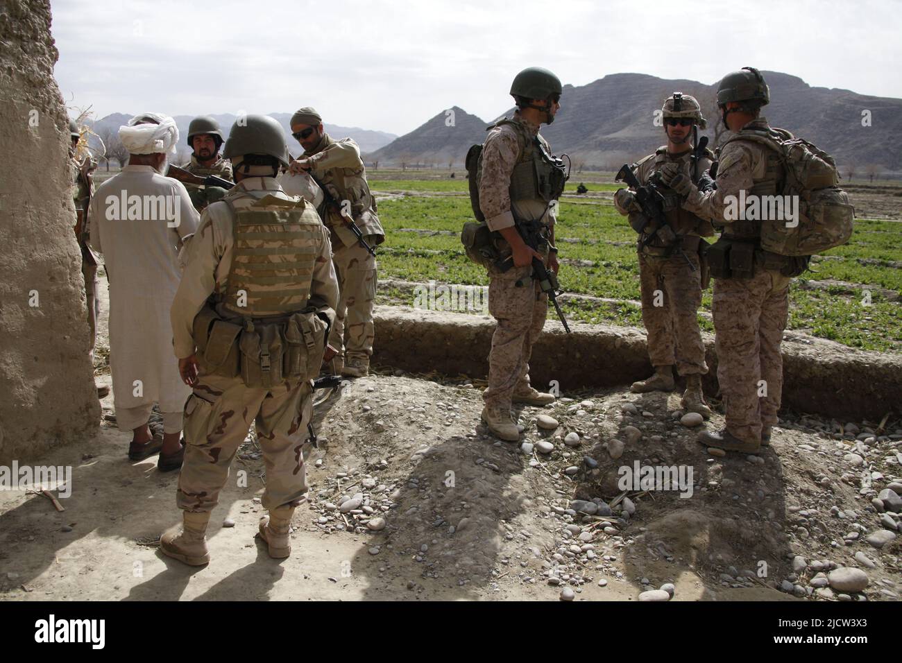 Afghanische Soldaten der Task Force (ATF) mit zwei britischen Royal Marines (rechts) befragen den Dorfältesten in den lokalen Gebieten (links) über die Aktivitäten der Taliban in Kajak Stockfoto