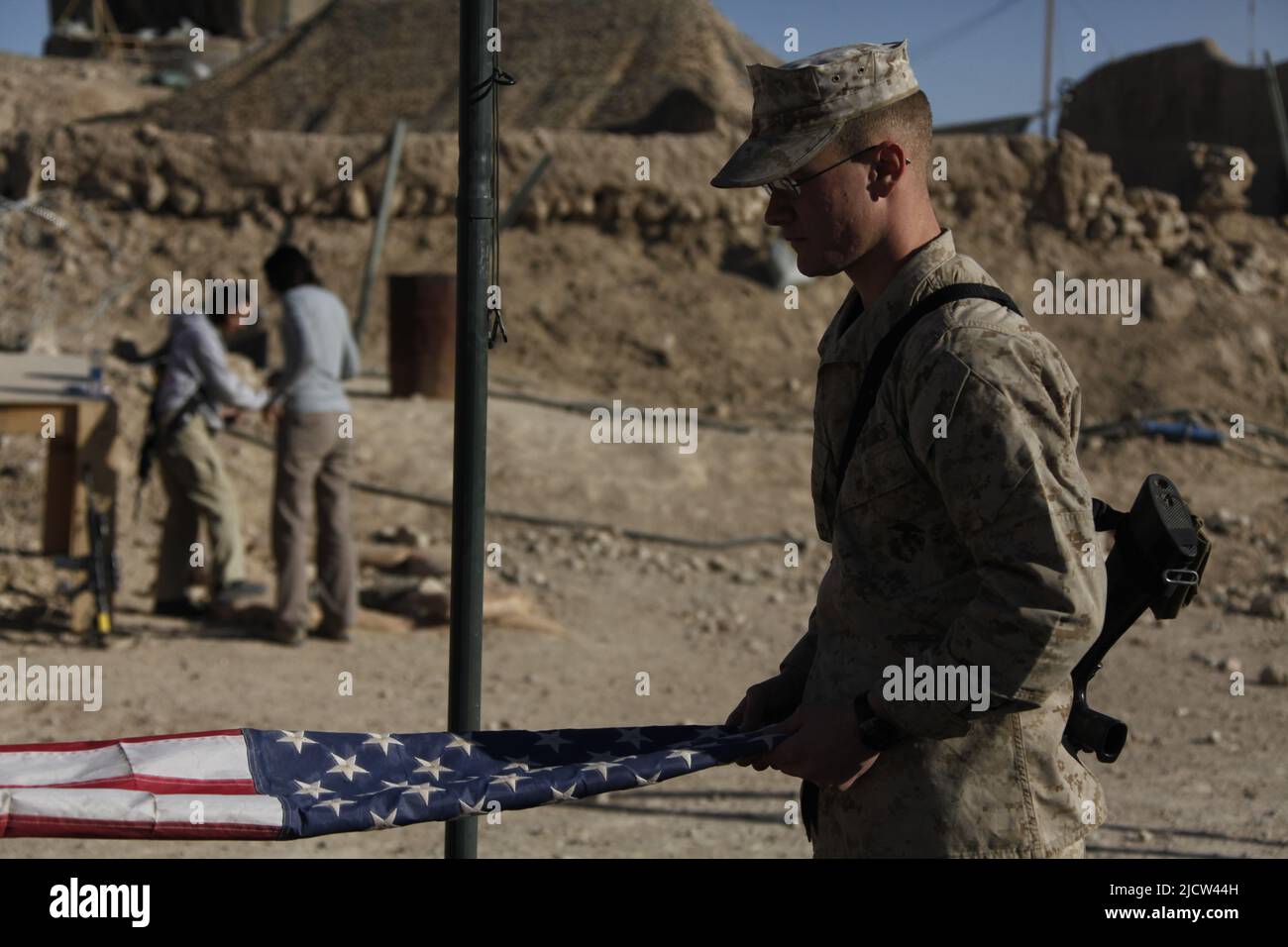 U.S. Marine Corps Lance CPL. Jacob H. Walter mit Combat Logistics Bataillon 4, Regimental Combat Team 6, faltet die amerikanischen Flaggen der Vortage Stockfoto