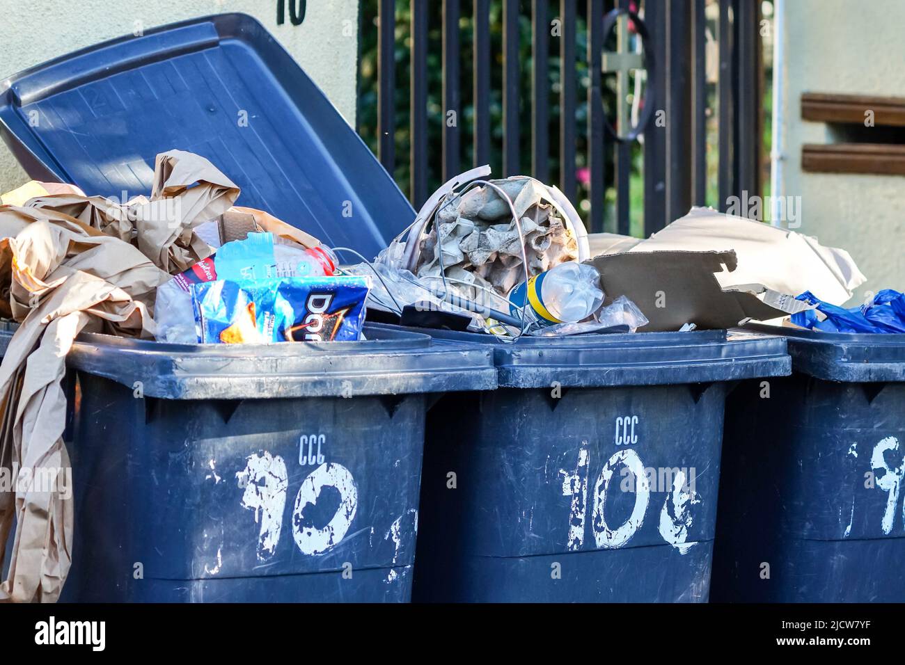 Mülltonnen, Mülltonnen, Mülltonnen, die mit Müll in der Nähe vor einem städtischen Haus in Kapstadt, Südafrika, überfüllt sind, Konzept öffentlicher Dienst Stockfoto