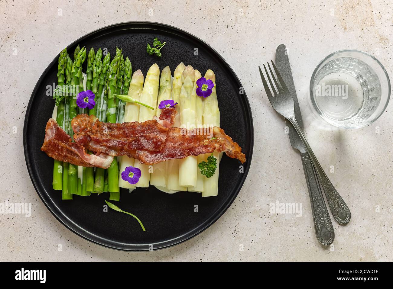 Grüner und weißer Spargel mit gebratenem Speck. Tolles saisonales Essen, einfaches Kochen zum Keto-Diät-Abendessen oder Mittagessen. Stockfoto