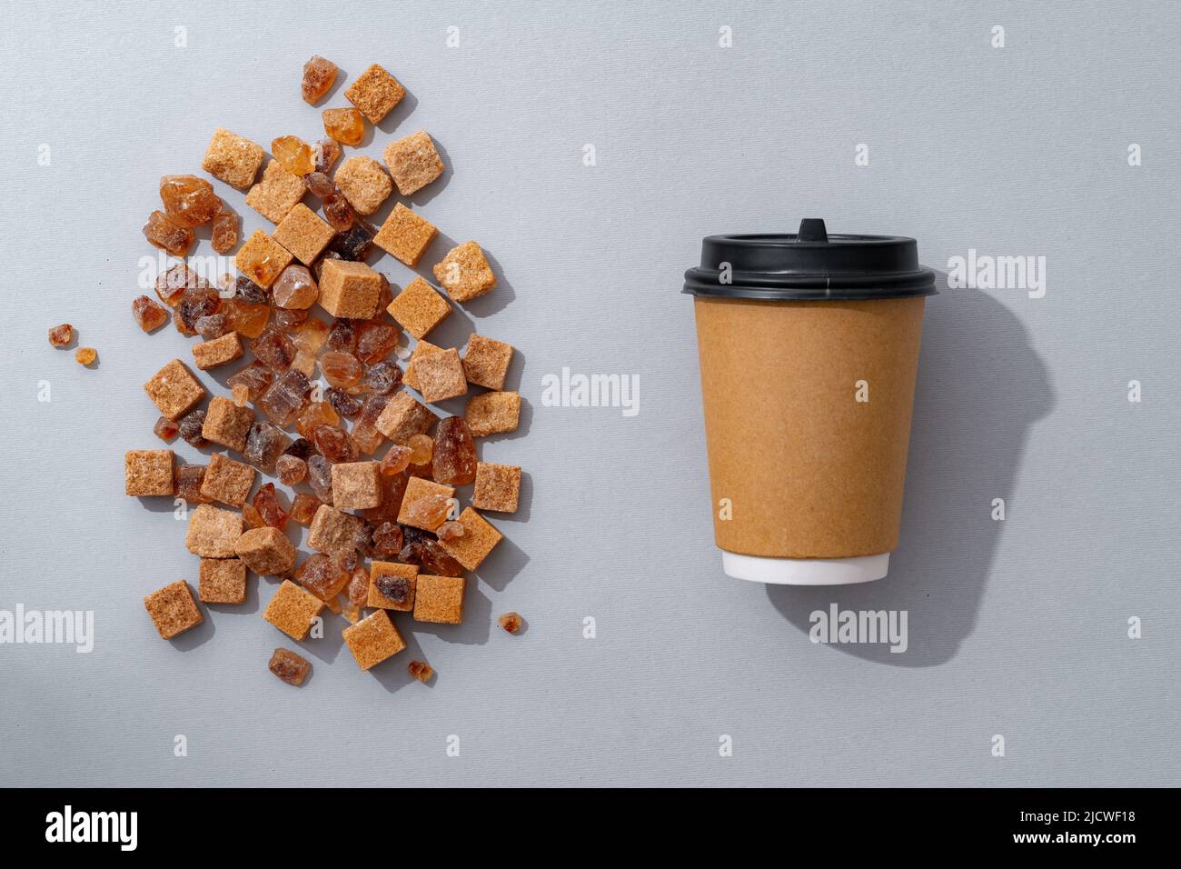 Tasse Kaffee mit braunem Zucker auf grauem Hintergrund Stockfoto