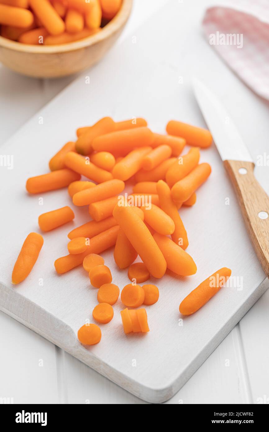 Baby Karottengemüse. Mini-orange Karotten auf weißem Tisch. Stockfoto