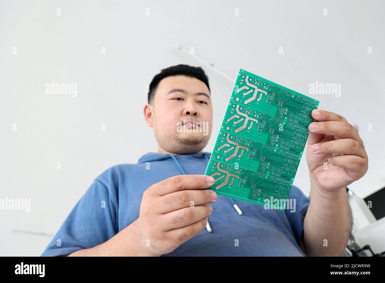 BINZHOU, CHINA - 16. JUNI 2022 - Ein Techniker schaut sich eine integrierte Leiterplatte an, die vom Unternehmen in der Stadt Xingfu im Bezirk Boxing, Binzhou C, entwickelt wurde Stockfoto