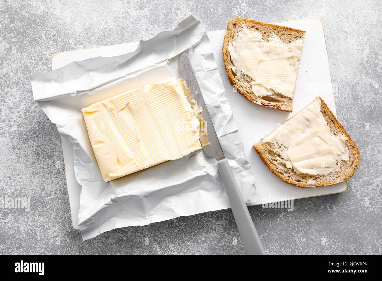 Butterblock mit Buttermesser in offener Packung. Butterbrot Stockfoto