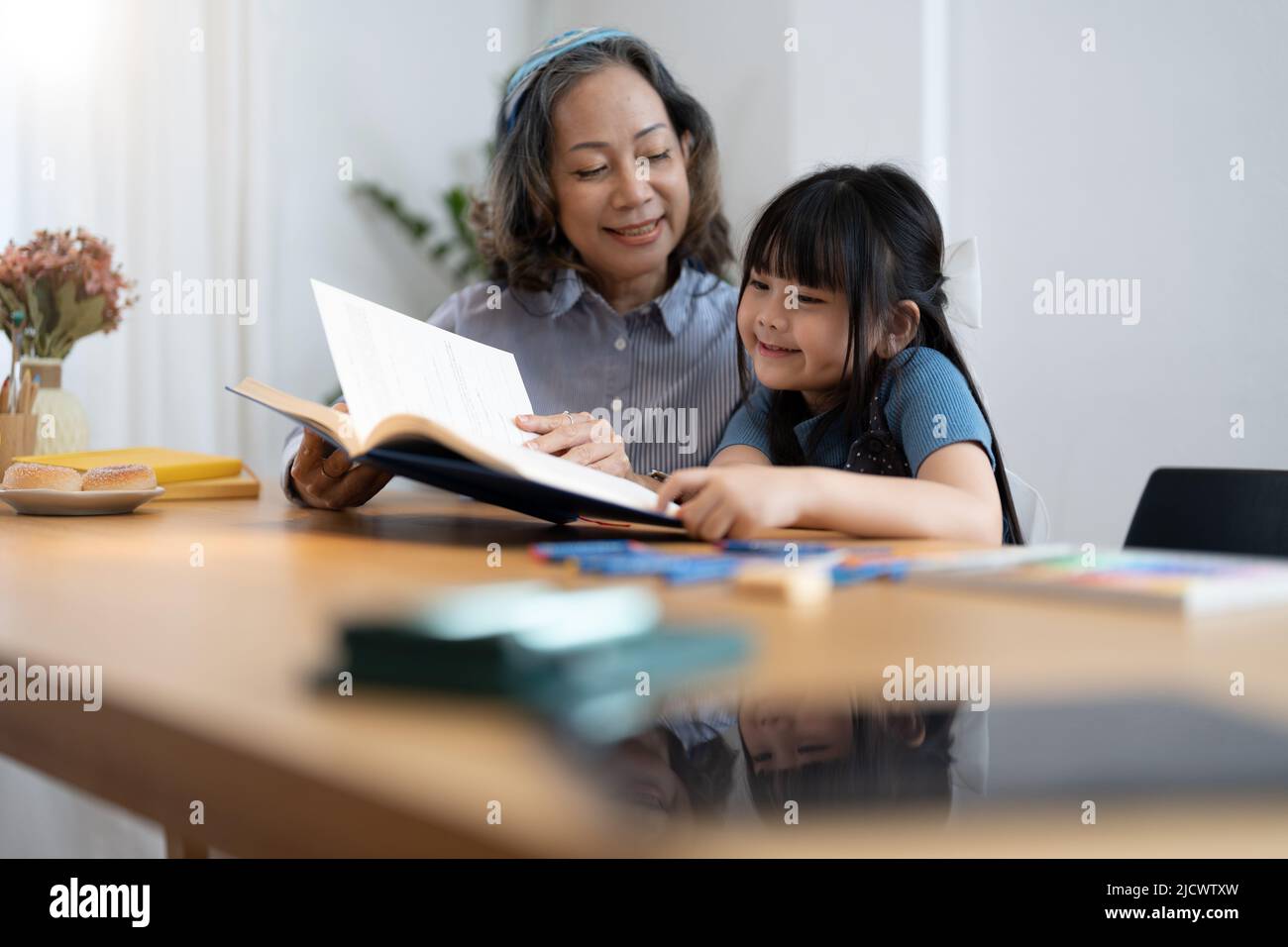 Enkelin Enkelin Großmutter Großmutter Lesen Buch Mädchen älter. asiatische Menschen. Stockfoto