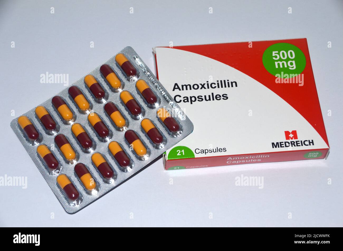 A Box of 21, Yellow & Burgundy 500mg Penicillin/Antibiotic Amoxicillin Capsules made by Medreich verschrieben für eine bakterielle Infektion, England, UK. Stockfoto