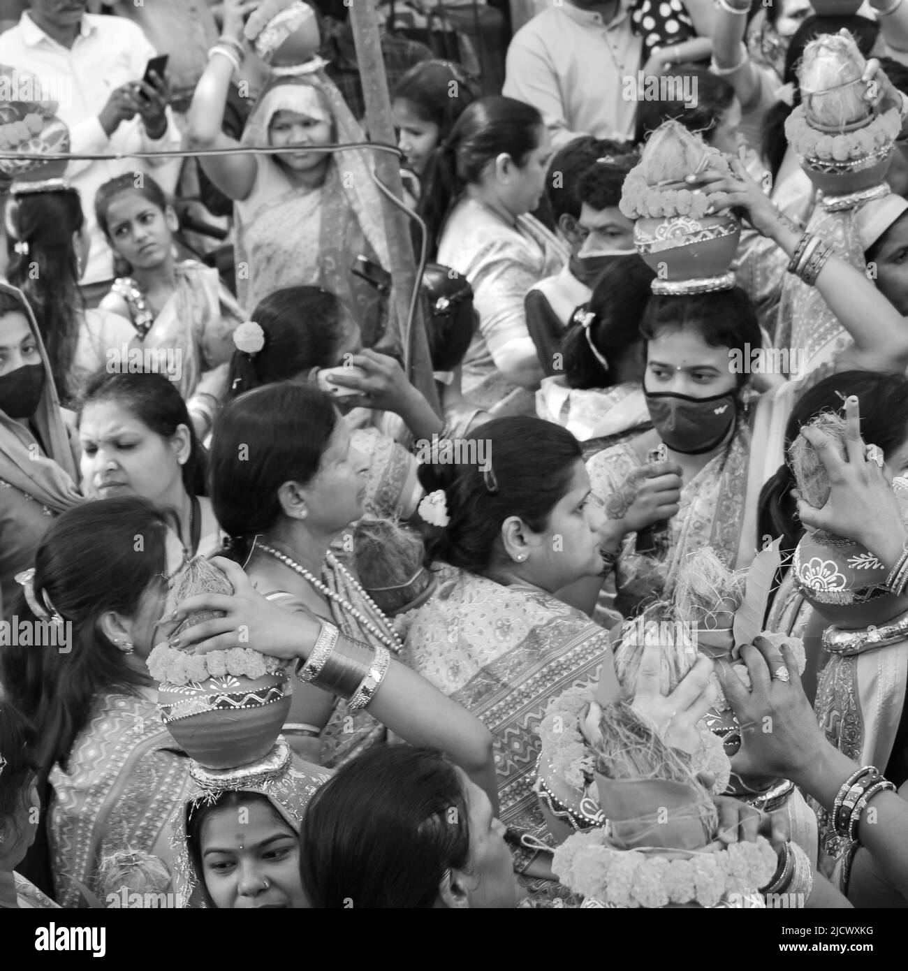 Delhi, Indien April 03 2022 - Frauen mit Kalash am Kopf während des Jagannath-Tempels Mangal Kalash Yatra tragen indische Hindu-Anhänger irdische Töpfe im Container Stockfoto