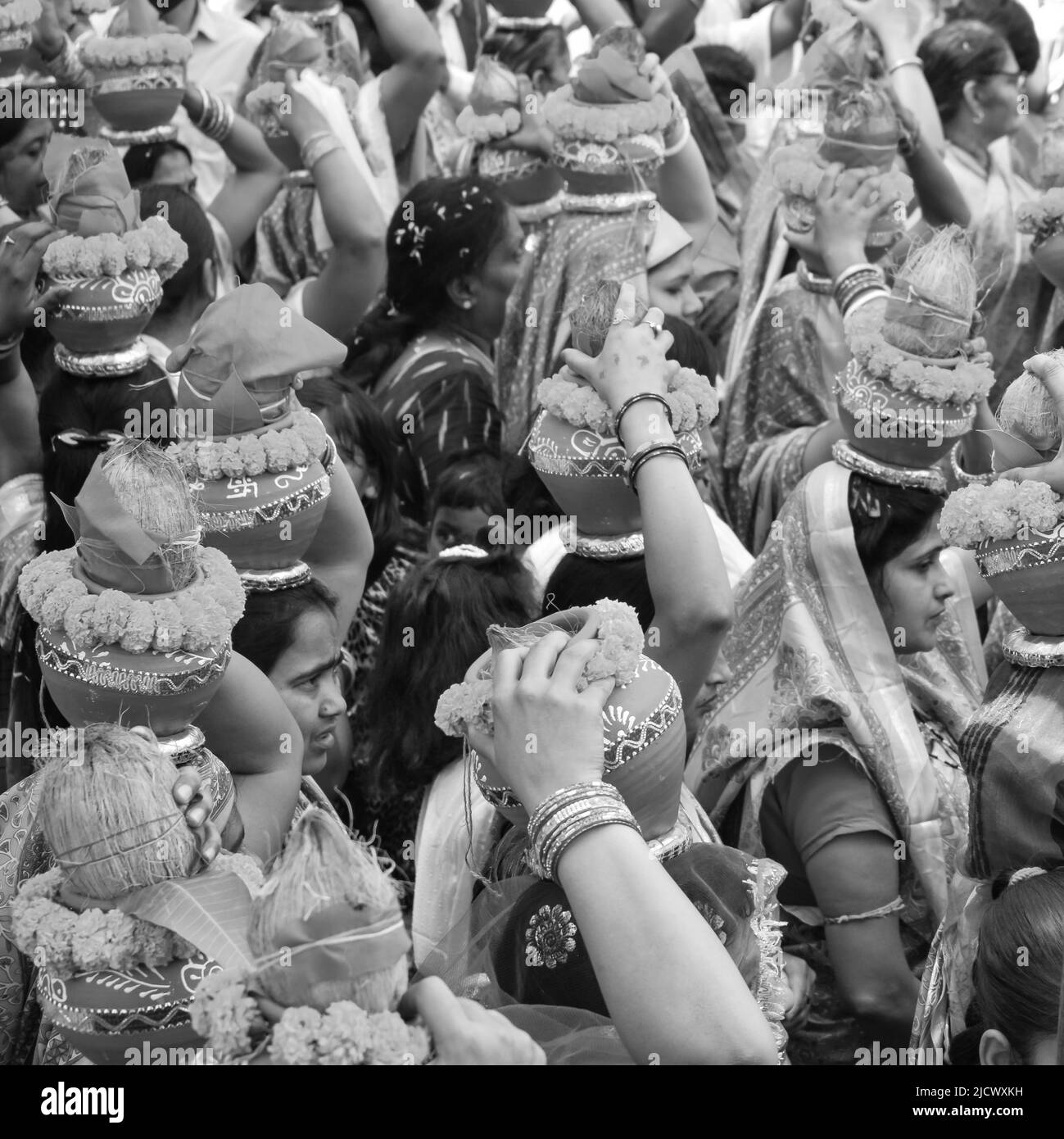 Delhi, Indien April 03 2022 - Frauen mit Kalash am Kopf während des Jagannath-Tempels Mangal Kalash Yatra tragen indische Hindu-Anhänger irdische Töpfe im Container Stockfoto