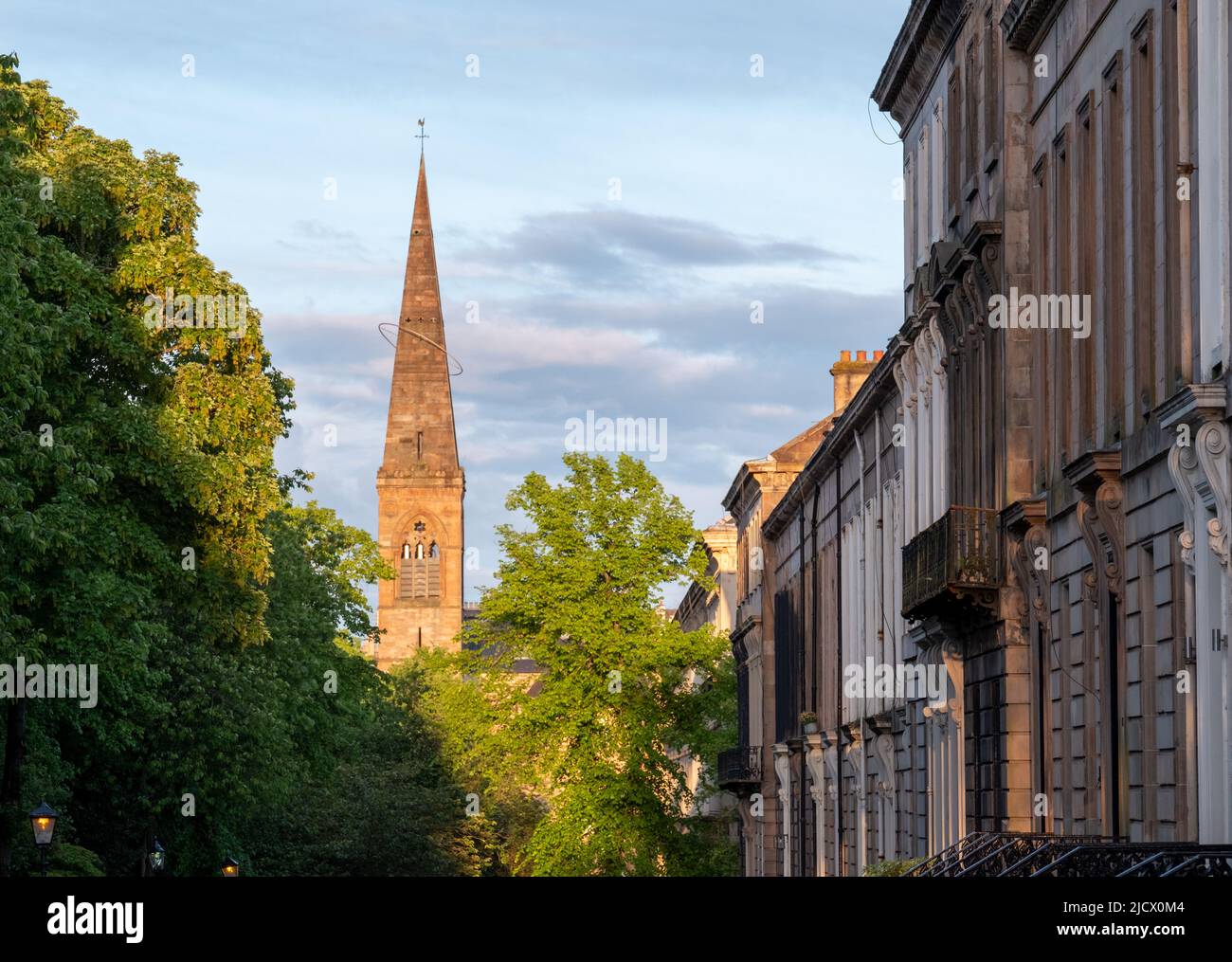 Spire der ehemaligen Kelvinside Pfarrkirche, heute das Oran Mor Kulturzentrum. Auf der rechten Seite, Terrassenimmobilien im West End der Stadt. Fotografiert bei Stockfoto