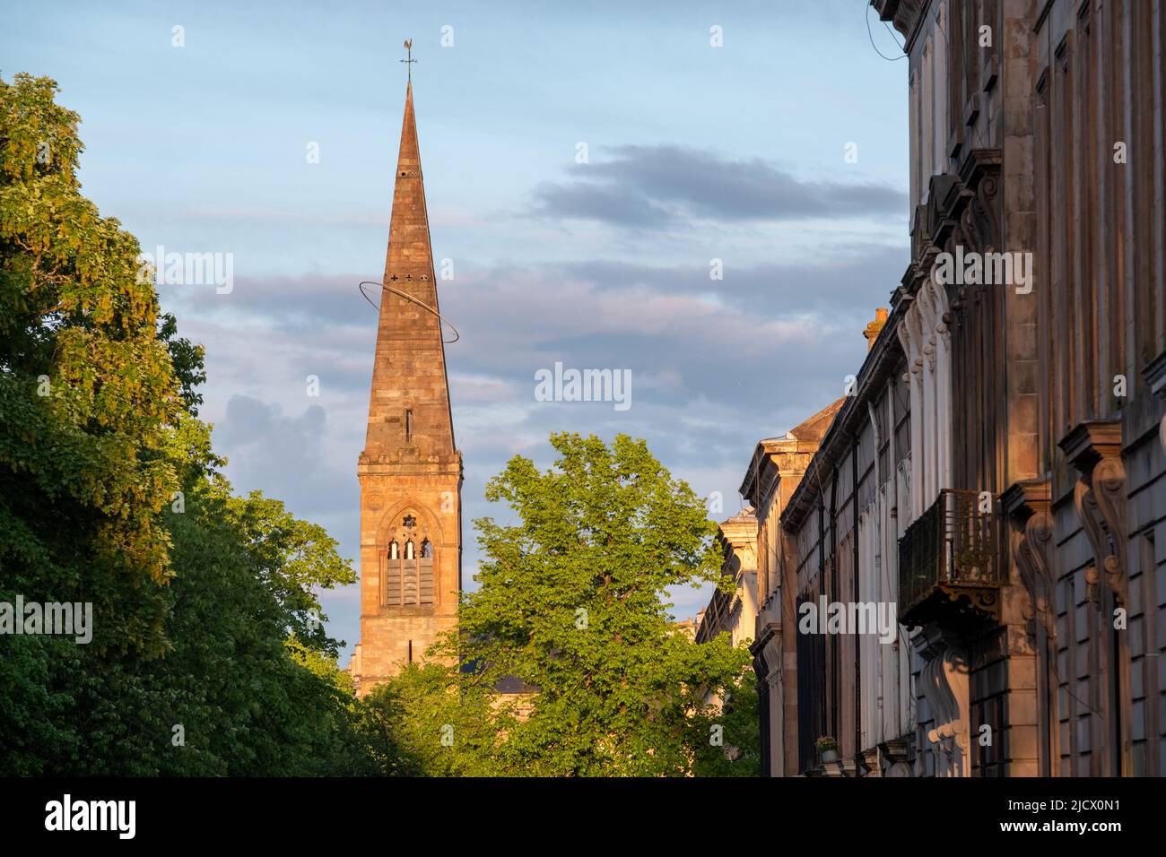 Spire der ehemaligen Kelvinside Pfarrkirche, heute das Oran Mor Kulturzentrum. Auf der rechten Seite, Terrassenimmobilien im West End der Stadt. Fotografiert bei Stockfoto