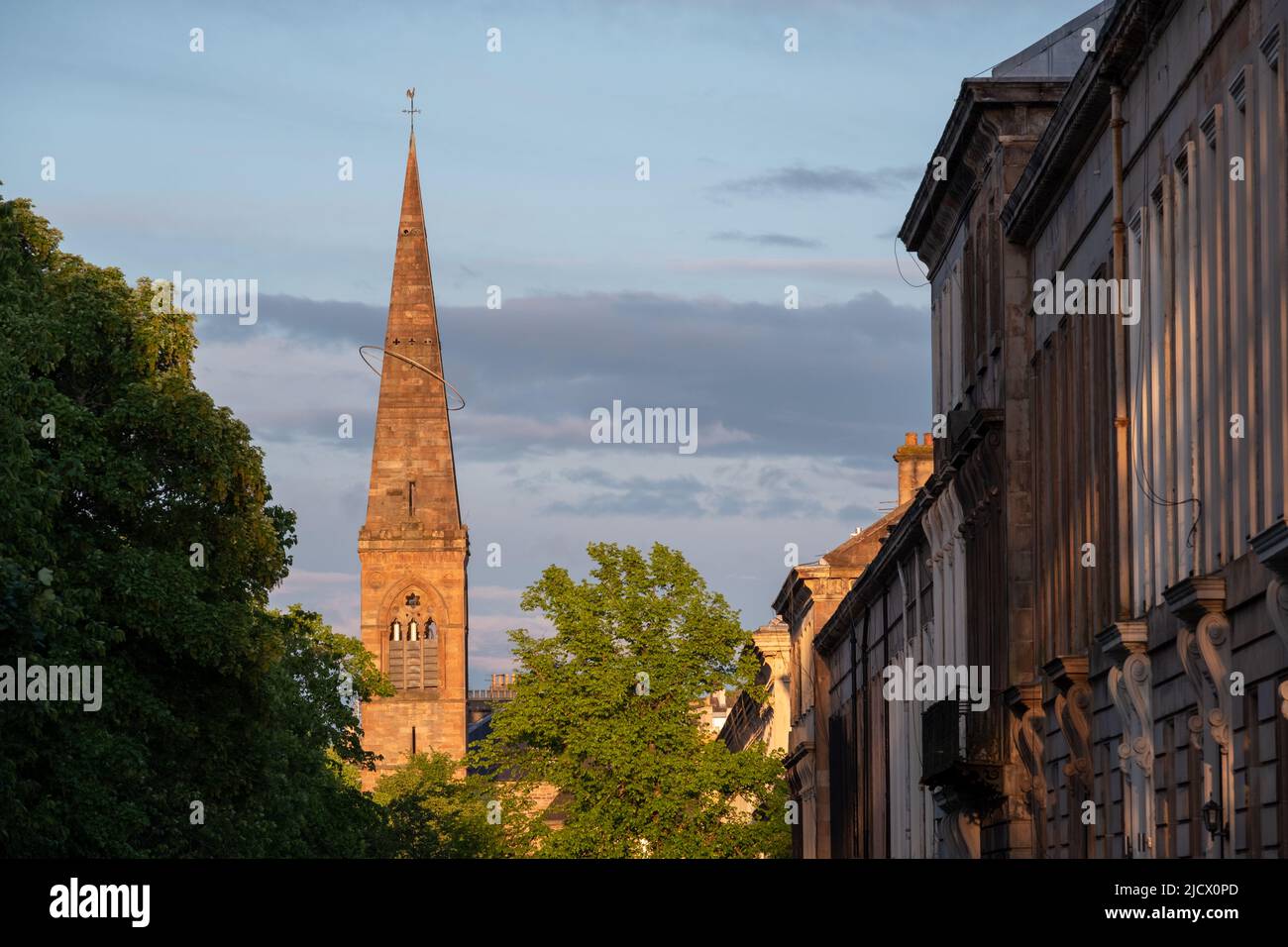 Spire der ehemaligen Kelvinside Pfarrkirche, heute das Oran Mor Kulturzentrum. Auf der rechten Seite, Terrassenimmobilien im West End der Stadt. Fotografiert bei Stockfoto