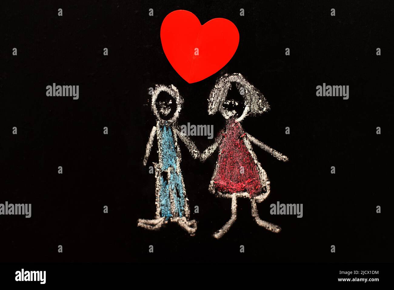 Kreidezeichnung Mann und Frau mit rotem Herz auf der Tafel. Nahaufnahme. Stockfoto