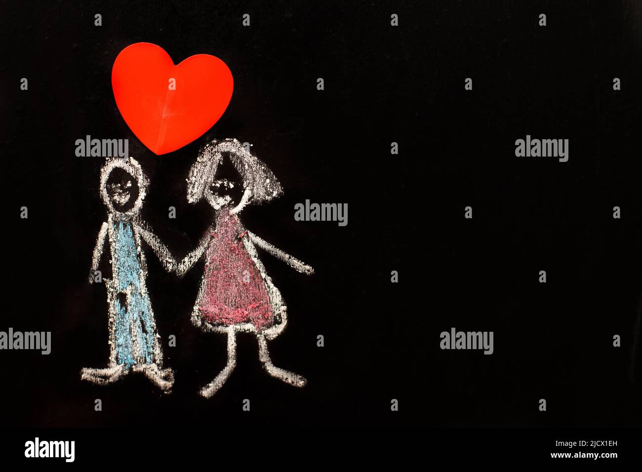 Kreidezeichnung Mann und Frau mit rotem Herz auf der Tafel. Nahaufnahme. Stockfoto