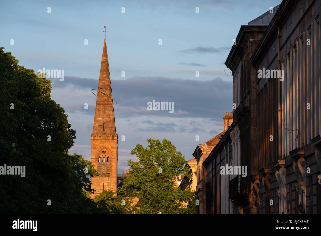 Spire der ehemaligen Kelvinside Pfarrkirche, heute das Oran Mor Kulturzentrum. Auf der rechten Seite, Terrassenimmobilien im West End der Stadt. Fotografiert bei Stockfoto