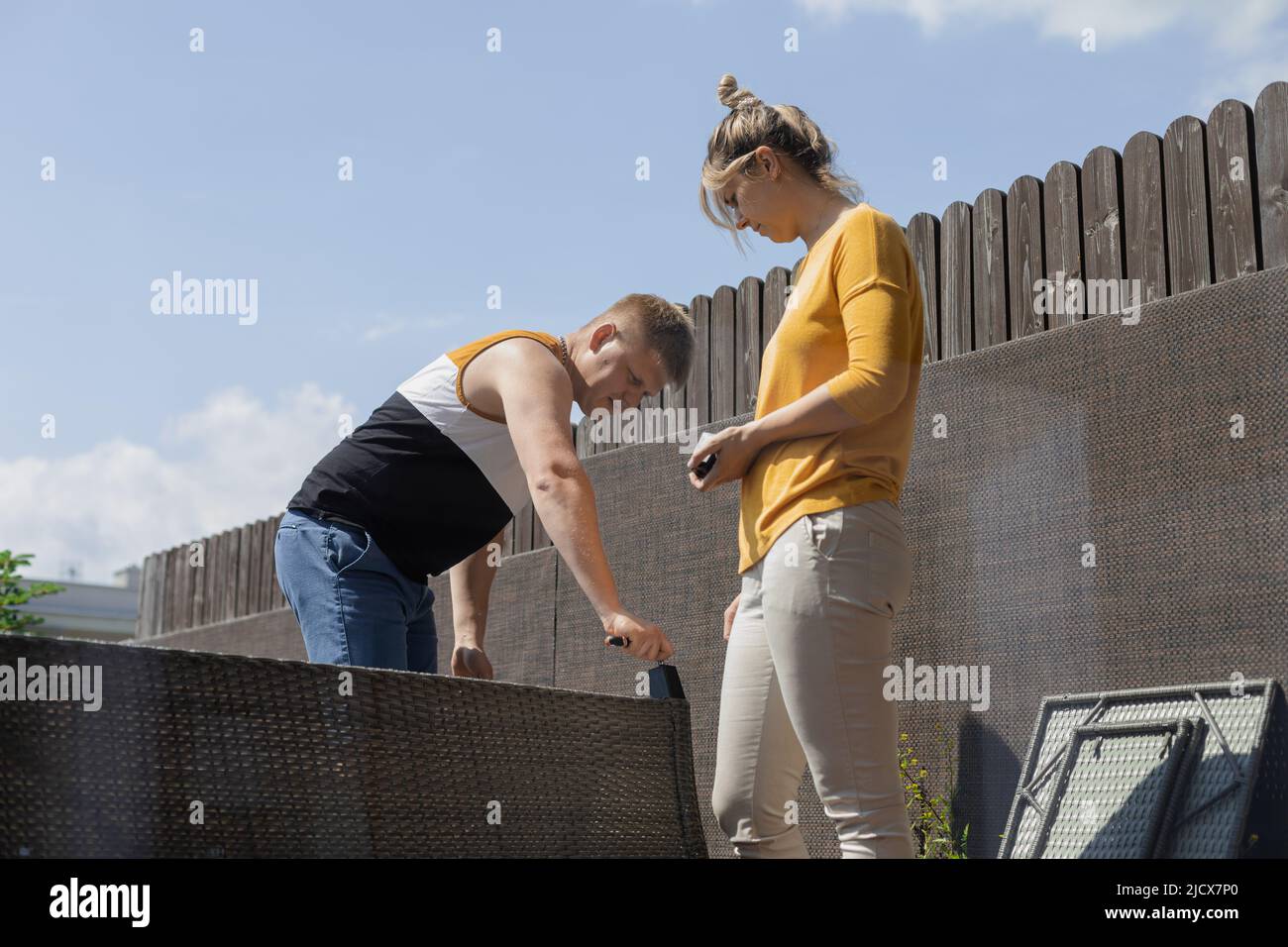 Paar Schwierigkeiten bei der Montage von Möbeln, die Schaffung und Vorbereitung Sofa für das Leben auf der Terrasse in Stadthaus Stockfoto