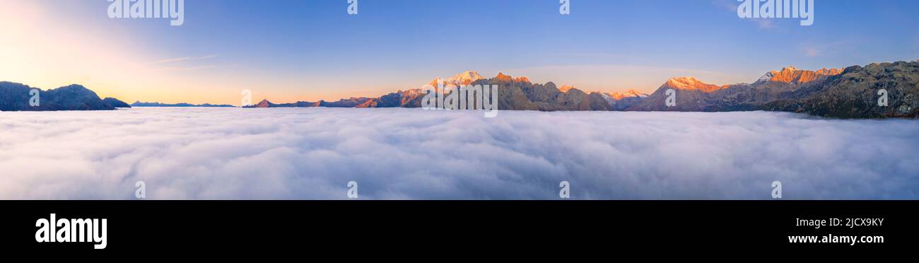 Panoramablick auf Valmalenco bei Sonnenaufgang bedeckt von einem Meer von Wolken, Valtellina, Lombardei, Italien, Europa Stockfoto
