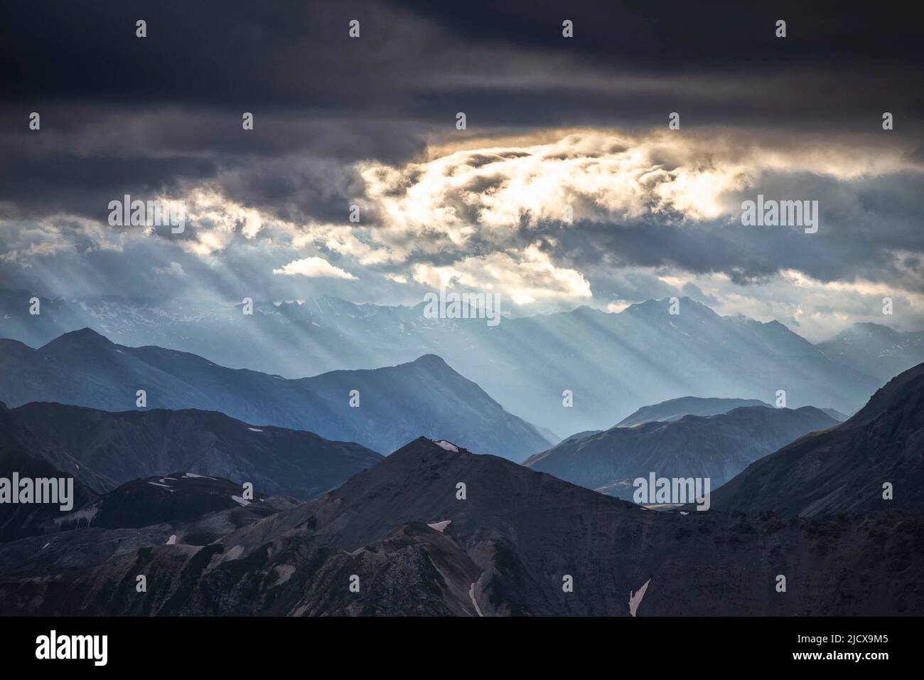 Sonnenstrahlen filtern bei Sonnenuntergang zwischen schwarzen Wolken, Stilfserjoch-Pass, Stilfserjoch-Nationalpark, Valtellina, Lombardei, Italien, Europa Stockfoto