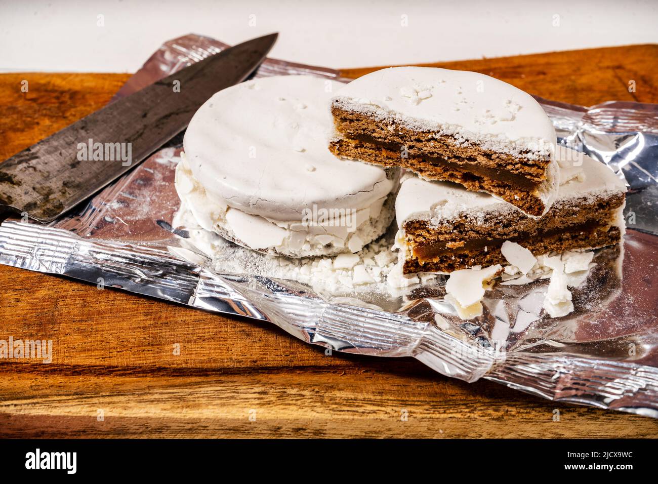 Typisch argentinische weiße Alfajores, gefüllt mit Dulce de leche und mit einer harten Glasur überzogen. Traditionelles Essen. Stockfoto