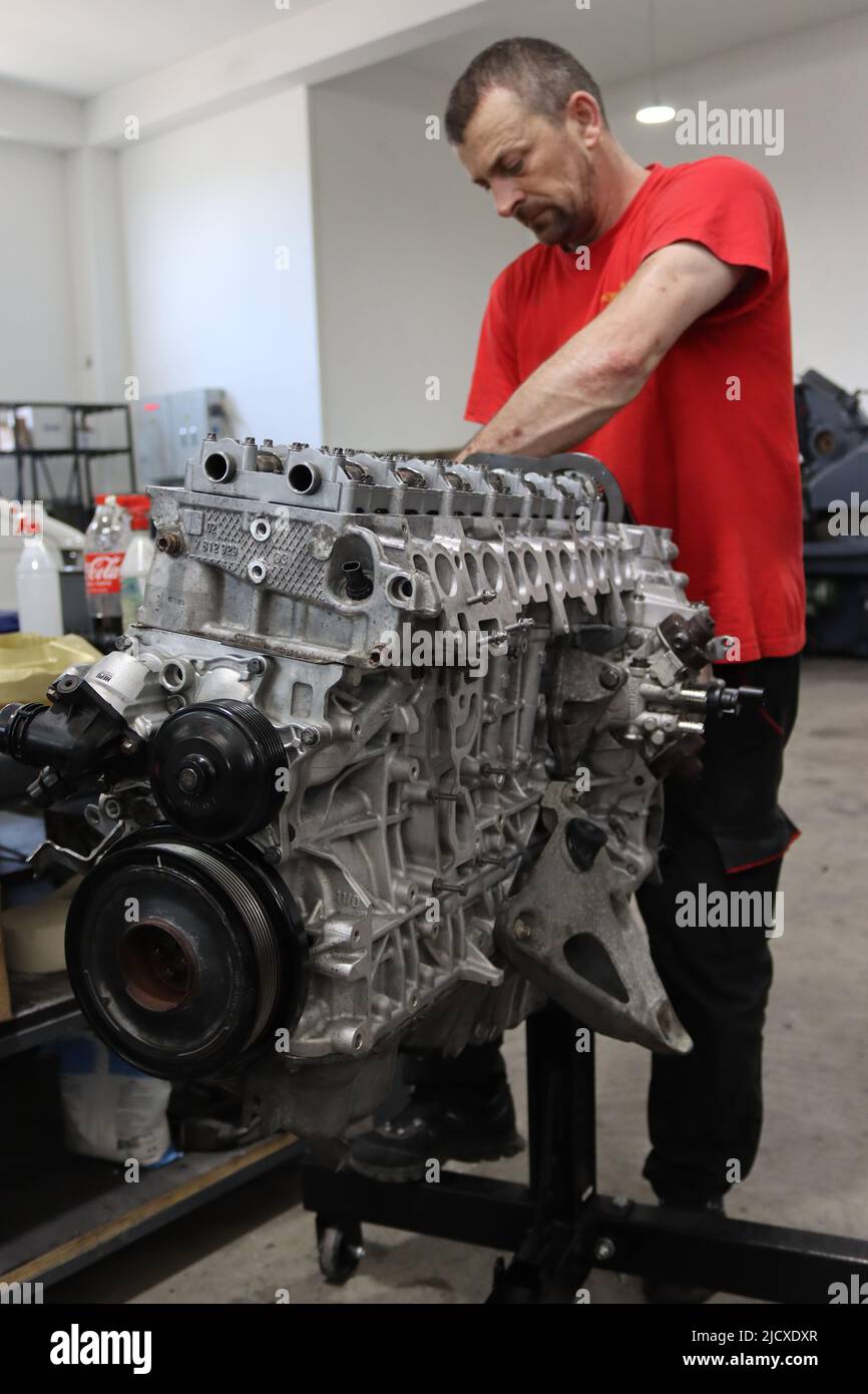 Mechaniker, der am Dieselmotor in der Motorreparatur-Werkstatt arbeitet Stockfoto