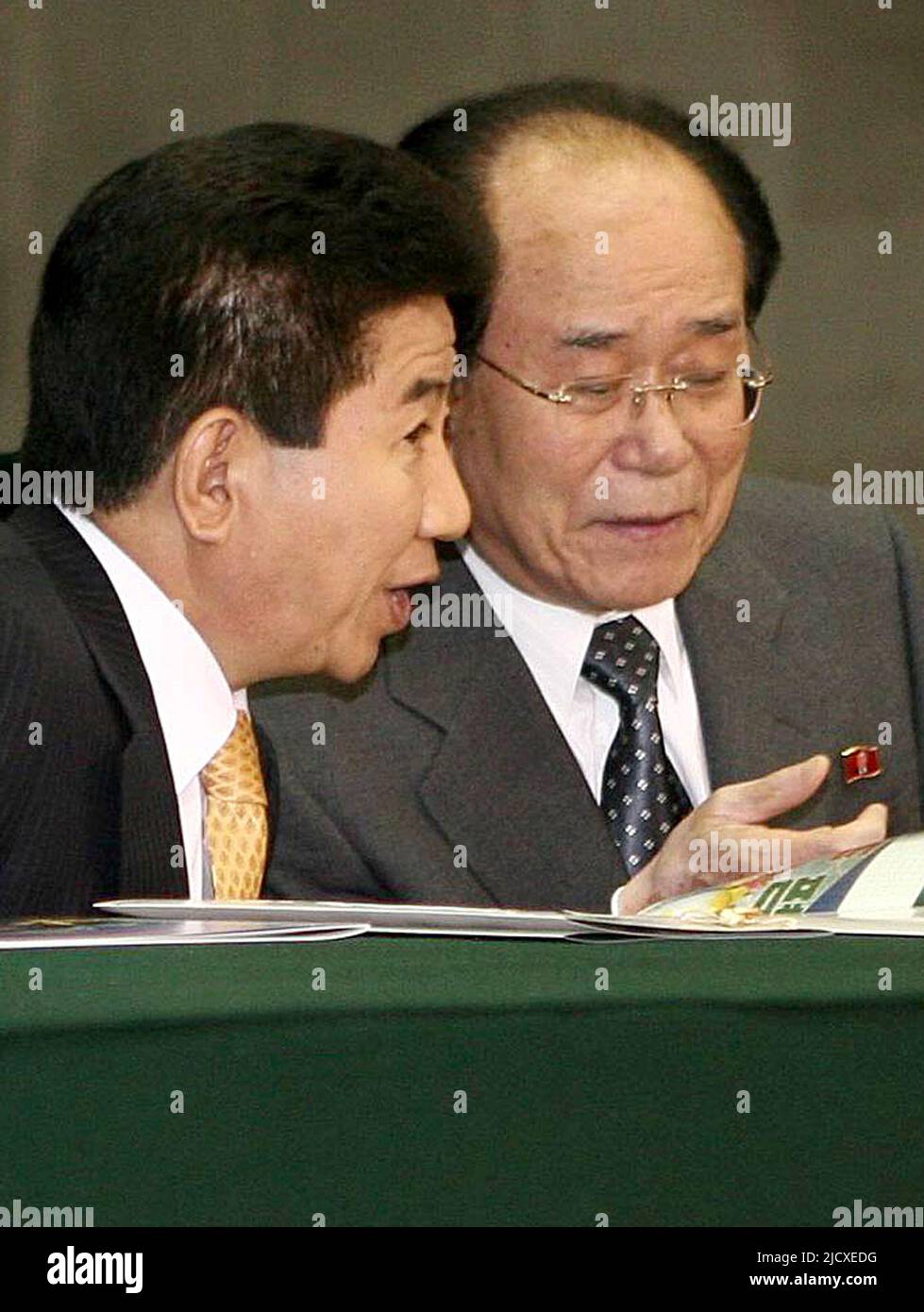 Der südkoreanische Präsident Roh Moo-hyun (L) spricht mit Kim Yong-nam, dem Präsidenten des nordkoreanischen parlaments, während sie die nordkoreanischen Arirang-Massenspiele im Stadion am 1. Mai in Pjöngjang am 3. Oktober 2007 verfolgen. Roh erlebte eine der typischen Massenspiele des Nordens, komplett mit Gänsehautsoldaten, tanzenden Schülerinnen und einem großen Flip-Card-Animationsbereich, der die Vereinigung unter dem kommunistischen Banner des Nordens fördert. Stockfoto