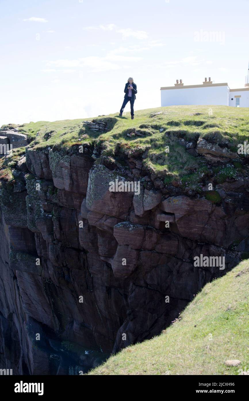 Frau, die auf der Klippe steht, Stoer Headland, Point of Stoer, Assynt, Schottland Stockfoto