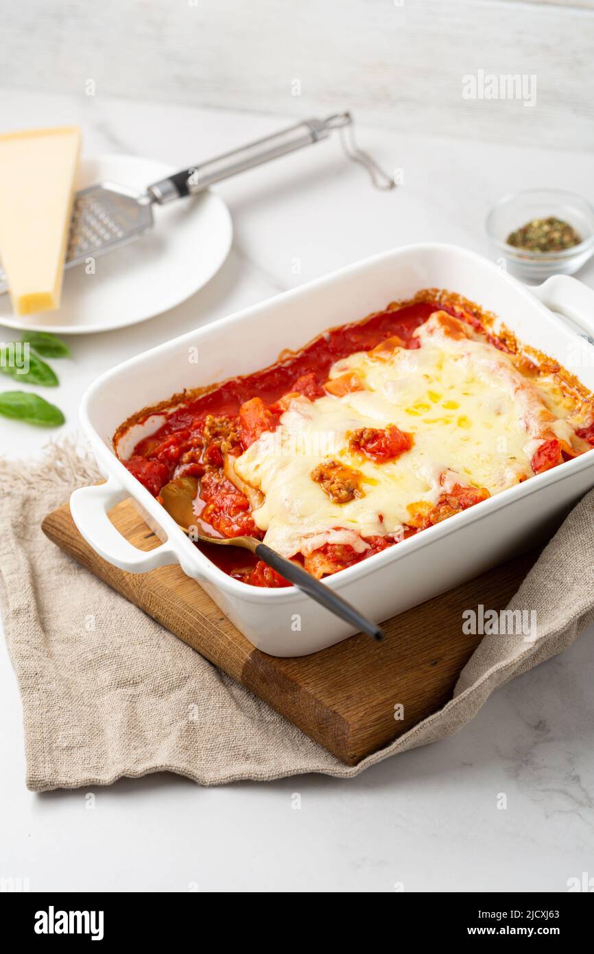 Nahaufnahme der italienischen gebackenen Pasta Canelloni Essen in Backform auf hellem Tisch Rezept Stockfoto