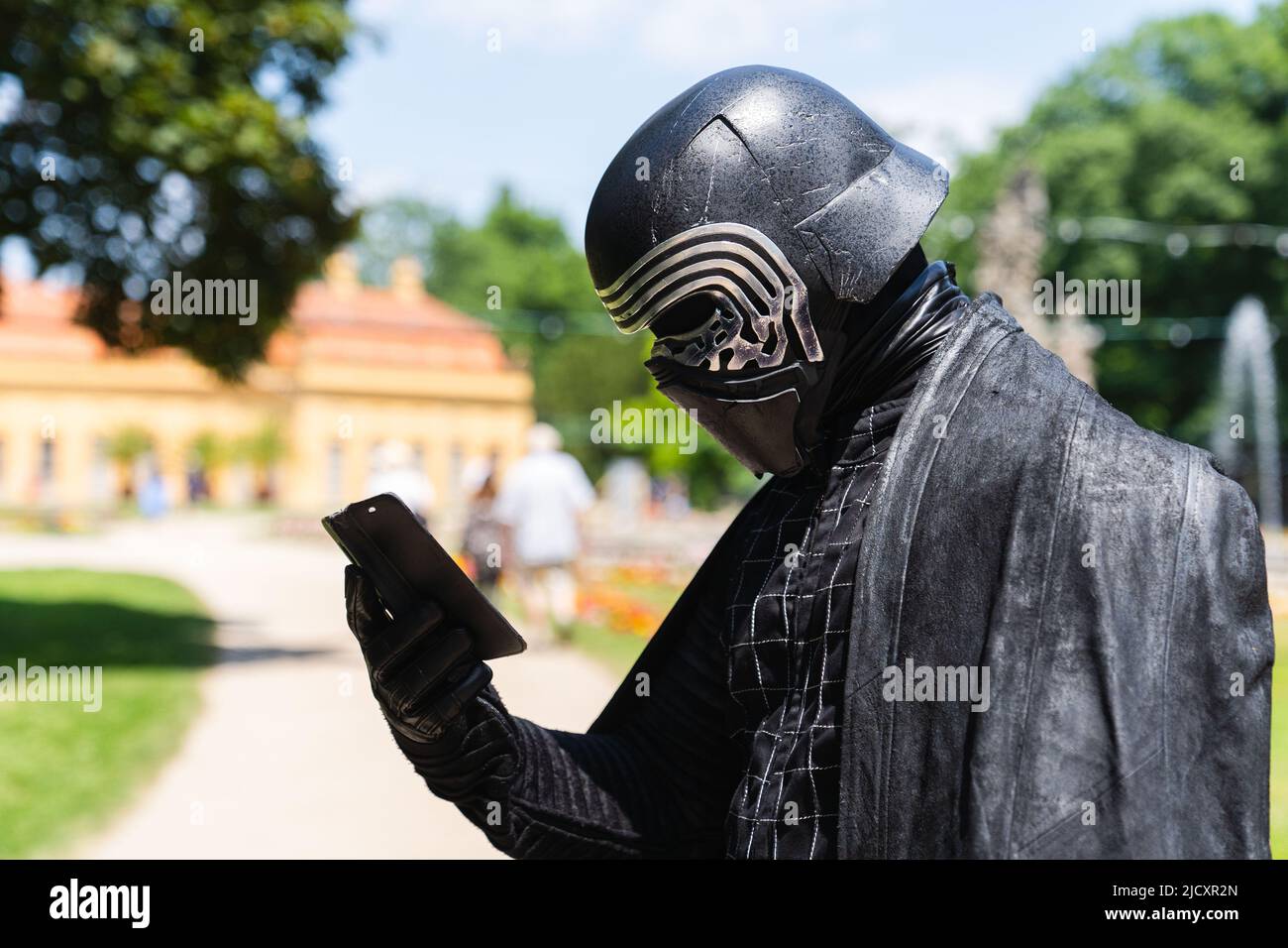 Erlangen, Deutschland. 16.. Juni 2022. Cosplayer Frank, hier in seinem Kostüm als Star Wars-Figur Kylo Ren, schaut auf sein Smartphone, während er den Comic Salon 2022 in Erlangen besucht. Quelle: Nicolas Armer/dpa/Alamy Live News Stockfoto