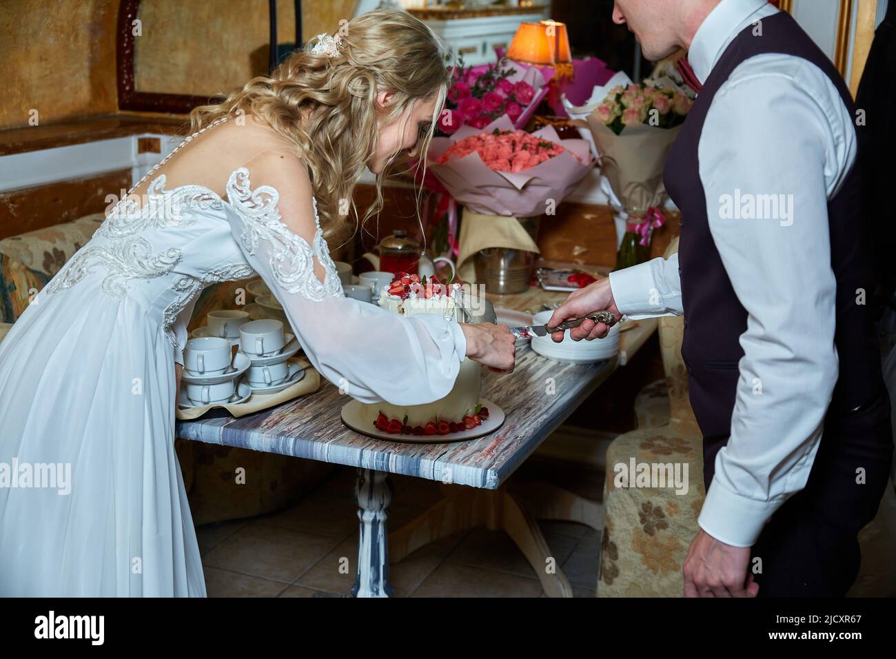 Braut und Bräutigam schneiden den Kuchen Stockfoto