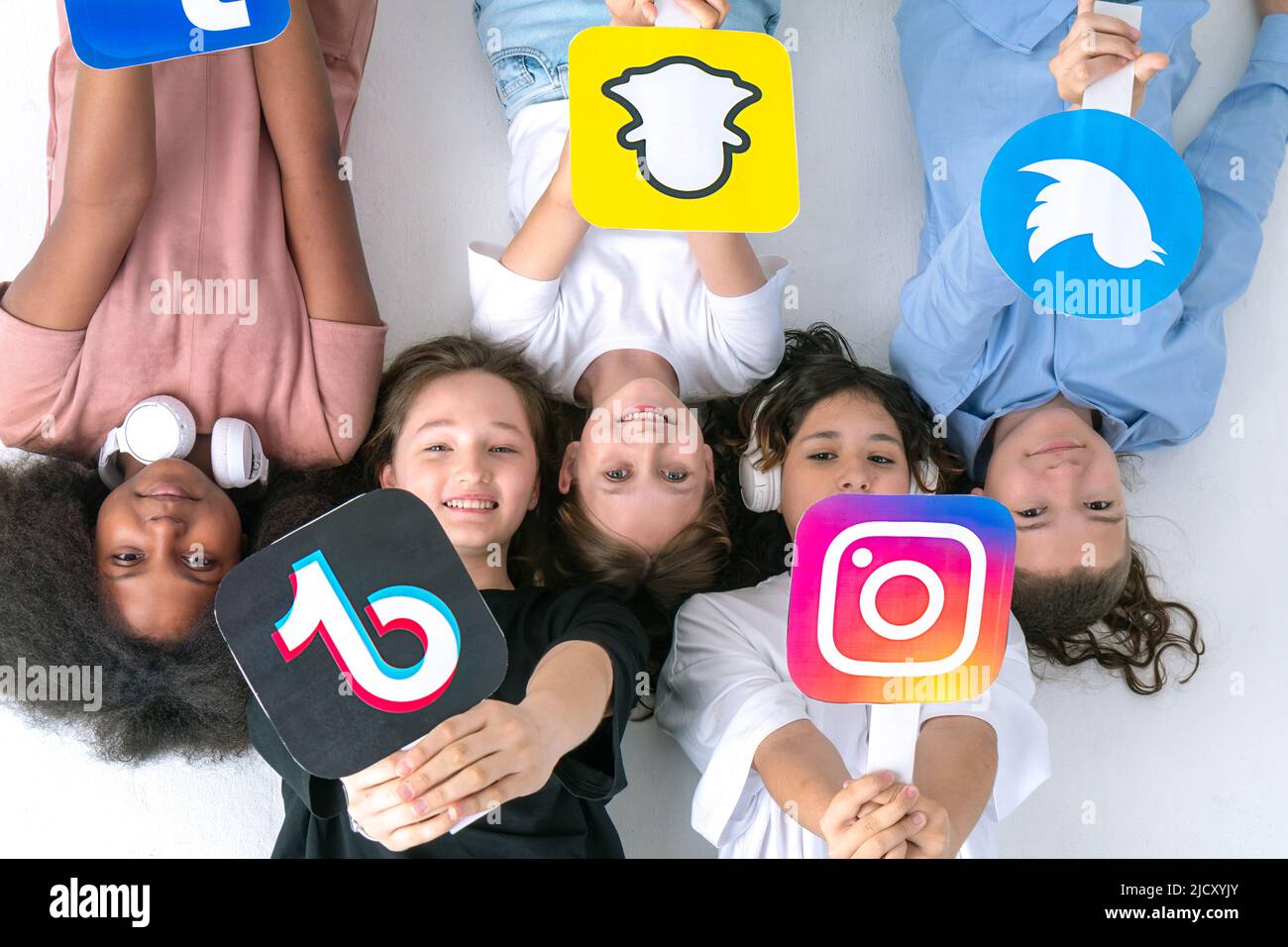 Multirassische Jugendliche Freunde Hände halten Social-Media-Symbole in ihren Händen. Jugendliche süchtig nach neuen Technologie-Trends - Konzept der Jugend, Technologie Stockfoto
