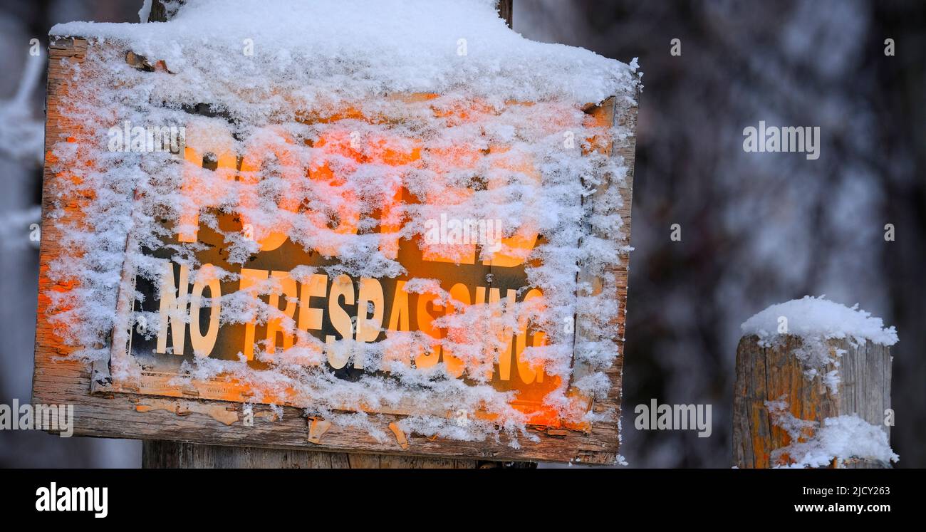 Im Winter gab es auf einem Holzzaunpfosten kein Hinweisschild mit einer schneeorangefarbenen Warnung Stockfoto
