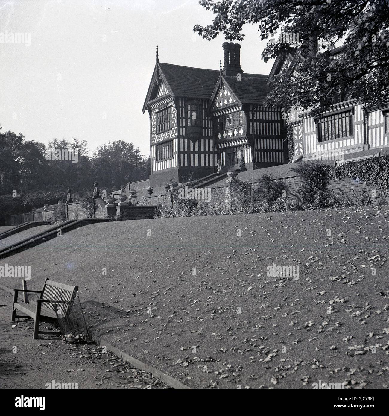 1940s, historisch, Blick von den Terrassen der Rückseite der Bramall Hall, Bramhall, Stockport, England, Großbritannien. Das aus dem 14.. Jahrhundert stammende, mit Fachwerkrahmen umrahmte Tudor-Herrenhaus, das später erweitert wurde, wurde 1935 von der Stadtverwaltung erworben und zu einem Museum. Die Familie Davenport, von der angenommen wird, dass sie das Haus gebaut hat, hielt das Herrenhaus über 500 Jahre lang. Stockfoto