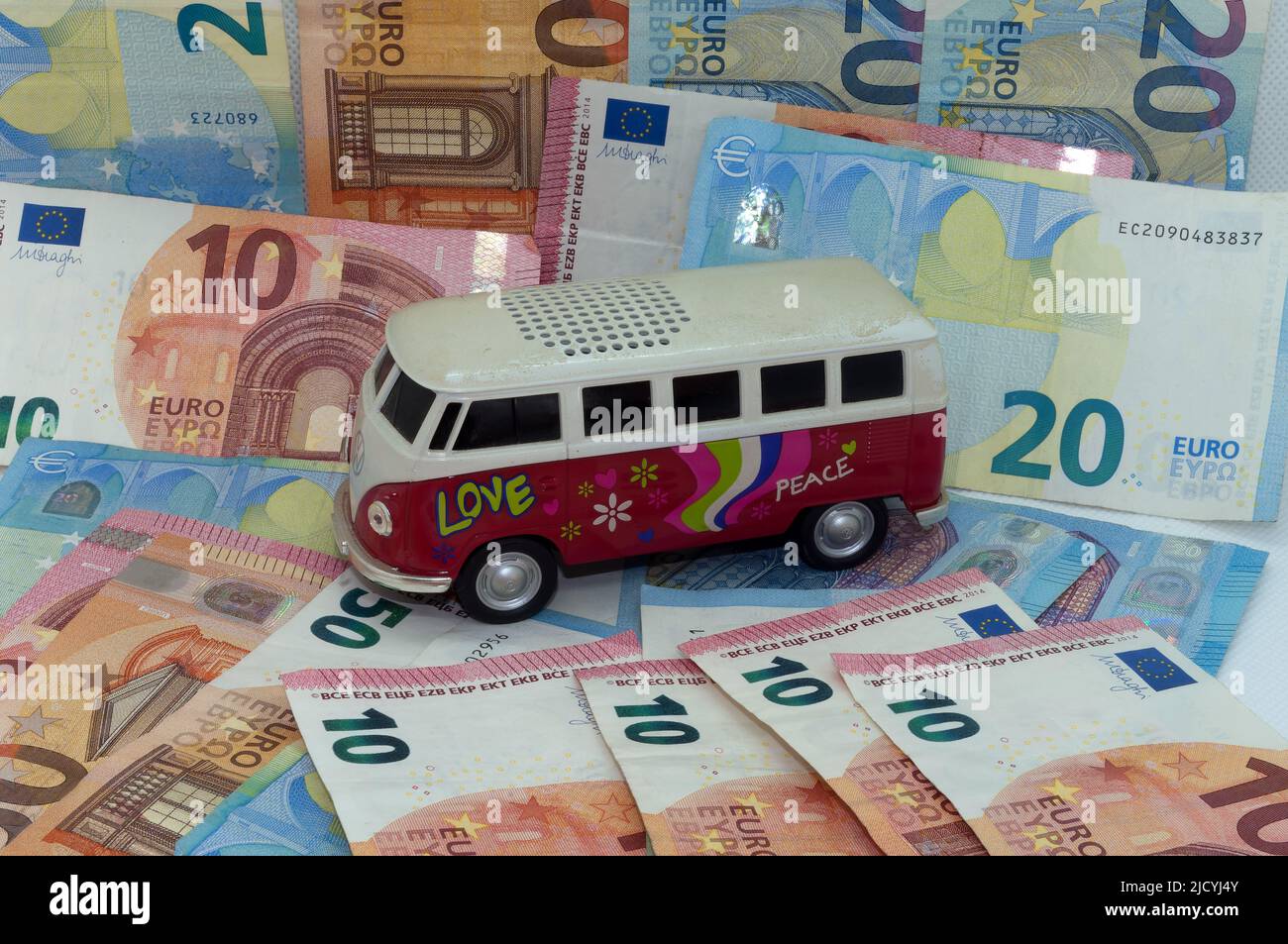 Symbolbild: Kosten, Inflation, Campingbus vor dem Hintergrund von Banknoten Stockfoto