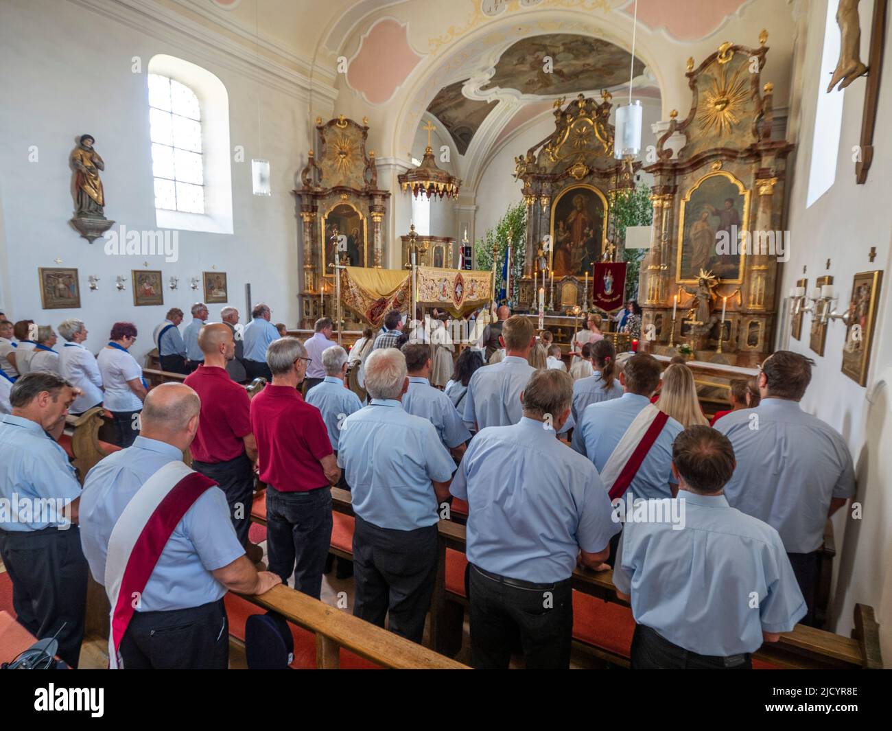 Während der Prozession liest der Priester vor den Gemeindemitgliedern eine Predigt vor. Katholiken des Dorfes Garham machen eine Prozession zu Ehren der Feier des Leibes und Blutes Jesu Christi. Stockfoto