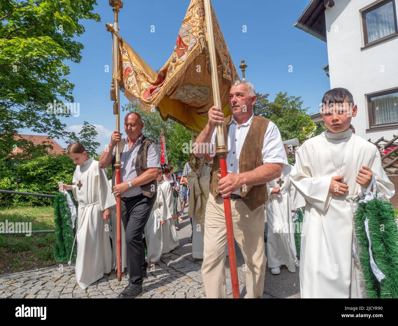 Die Teilnehmer der Prozession tragen einen Baldachin über dem Priester. Katholiken des Dorfes Garham machen eine Prozession zu Ehren der Feier des Leibes und Blutes Jesu Christi. Stockfoto