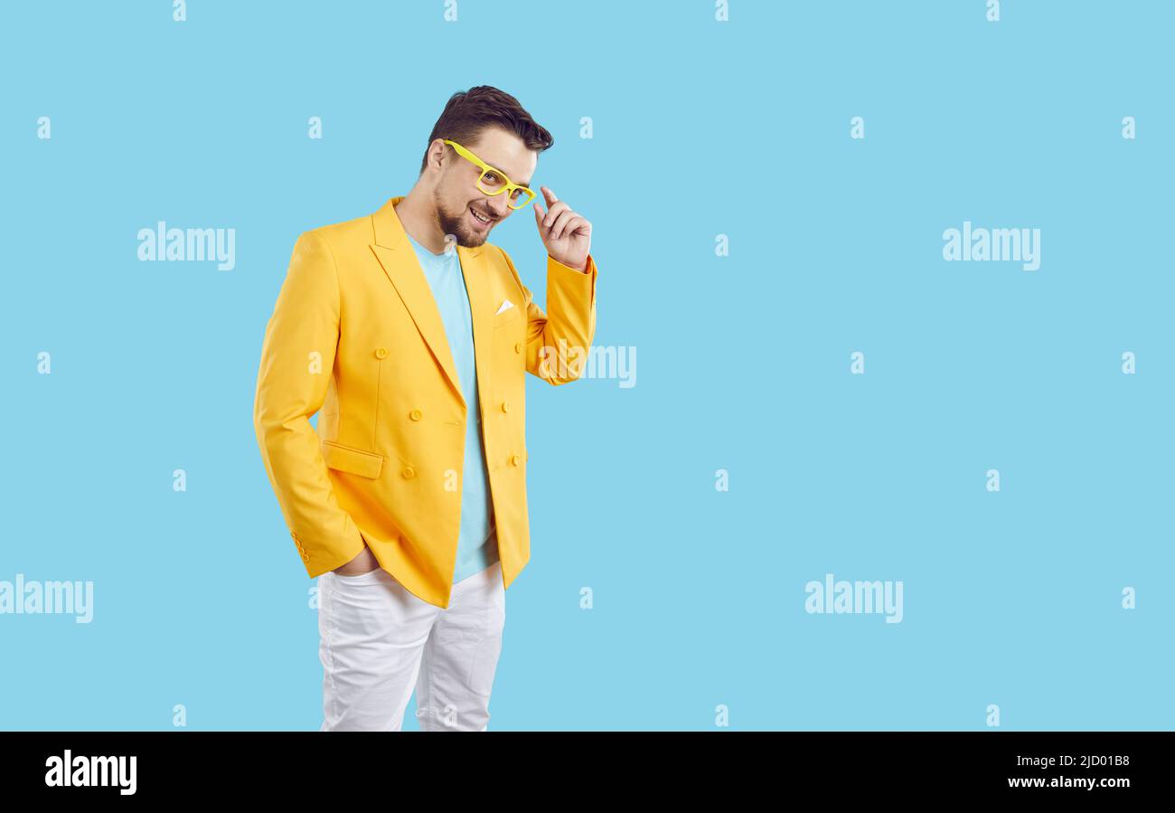 Porträt von fröhlich cool und stilvoll Millennial Mann in buntem Outfit auf hellblauem Hintergrund. Stockfoto