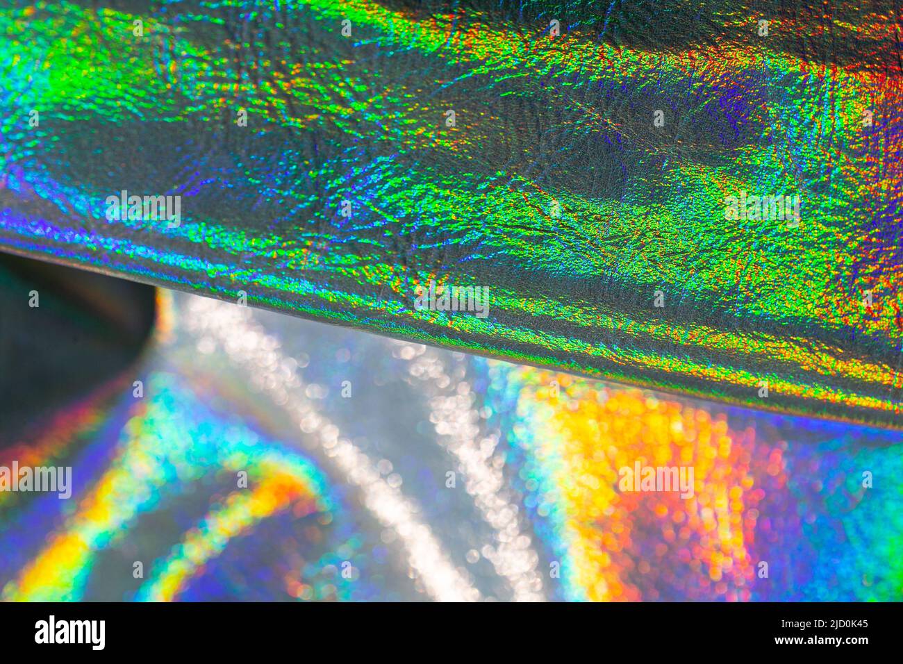 Holografische Tapete in Silber, lila und grünen Farben. Textur mit schillernden Wellen.schöne metallisch glänzenden Stoff.Metall holographischen Material. Stockfoto