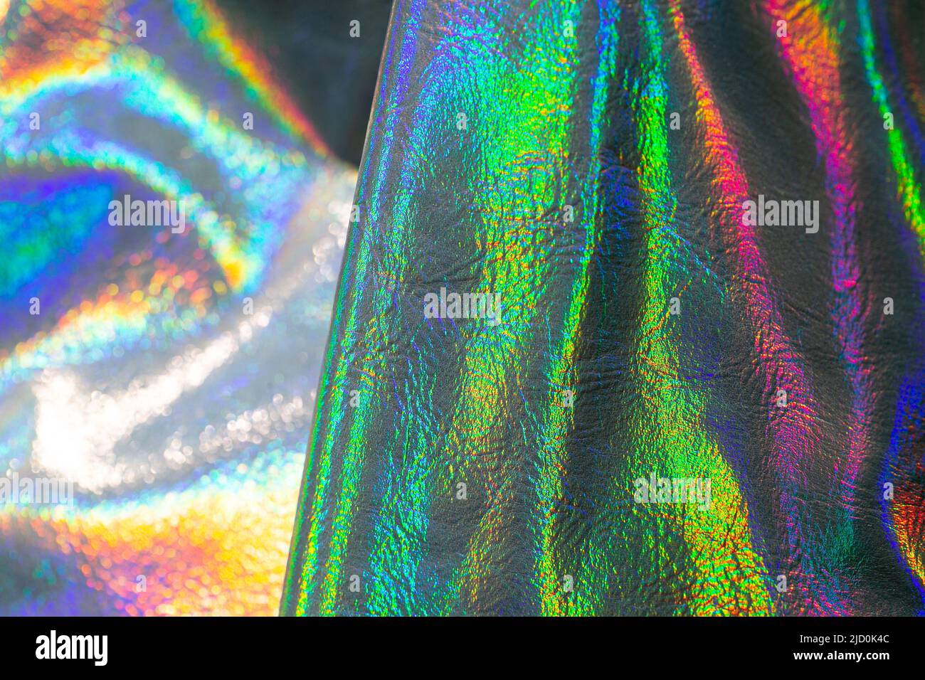 Holografische Tapete in Silber, Lila und Grün. Struktur mit Wellen und folds.beautiful metallisch glänzendem Stoff. Trendiger holografischer Hintergrund Stockfoto