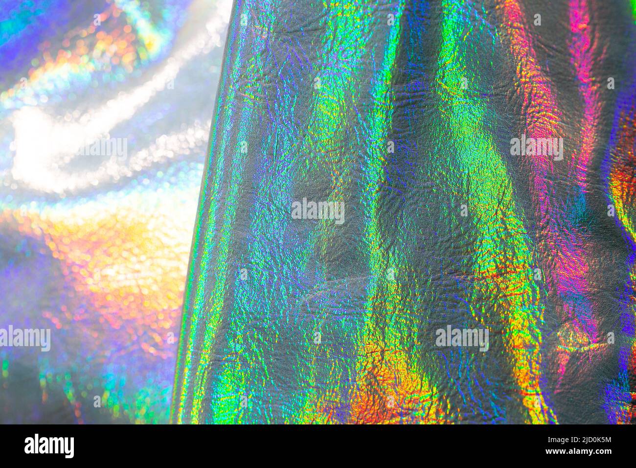 Holografische Tapete in Silber, Lila und Grün. Textur mit schillernden Wellen und folds.beautiful metallisch glänzendem Stoff. Trendige holografische Stockfoto