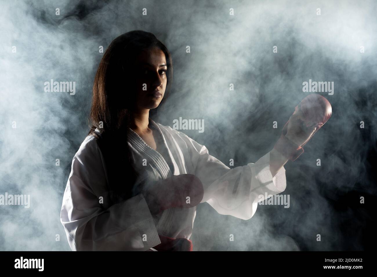 Schönes Mädchen Ausübung Karate Pose vor Nebel Hintergrund Stockfoto