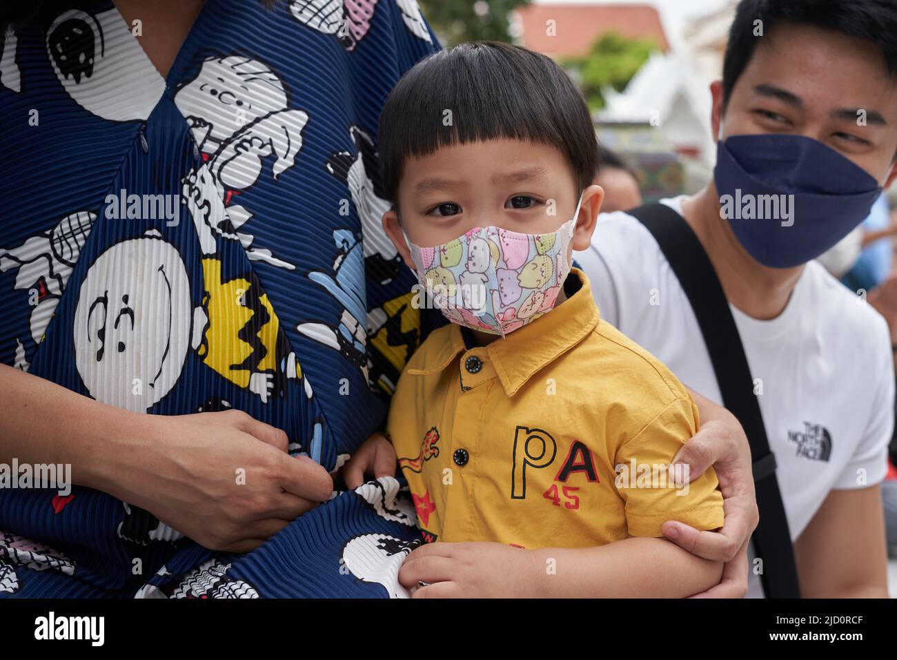 Bangkok, Thailand, 16. februar 2022: Kleines asiatisches Kind, das mit einer Facila-Maske auf die Kamera schaut Stockfoto